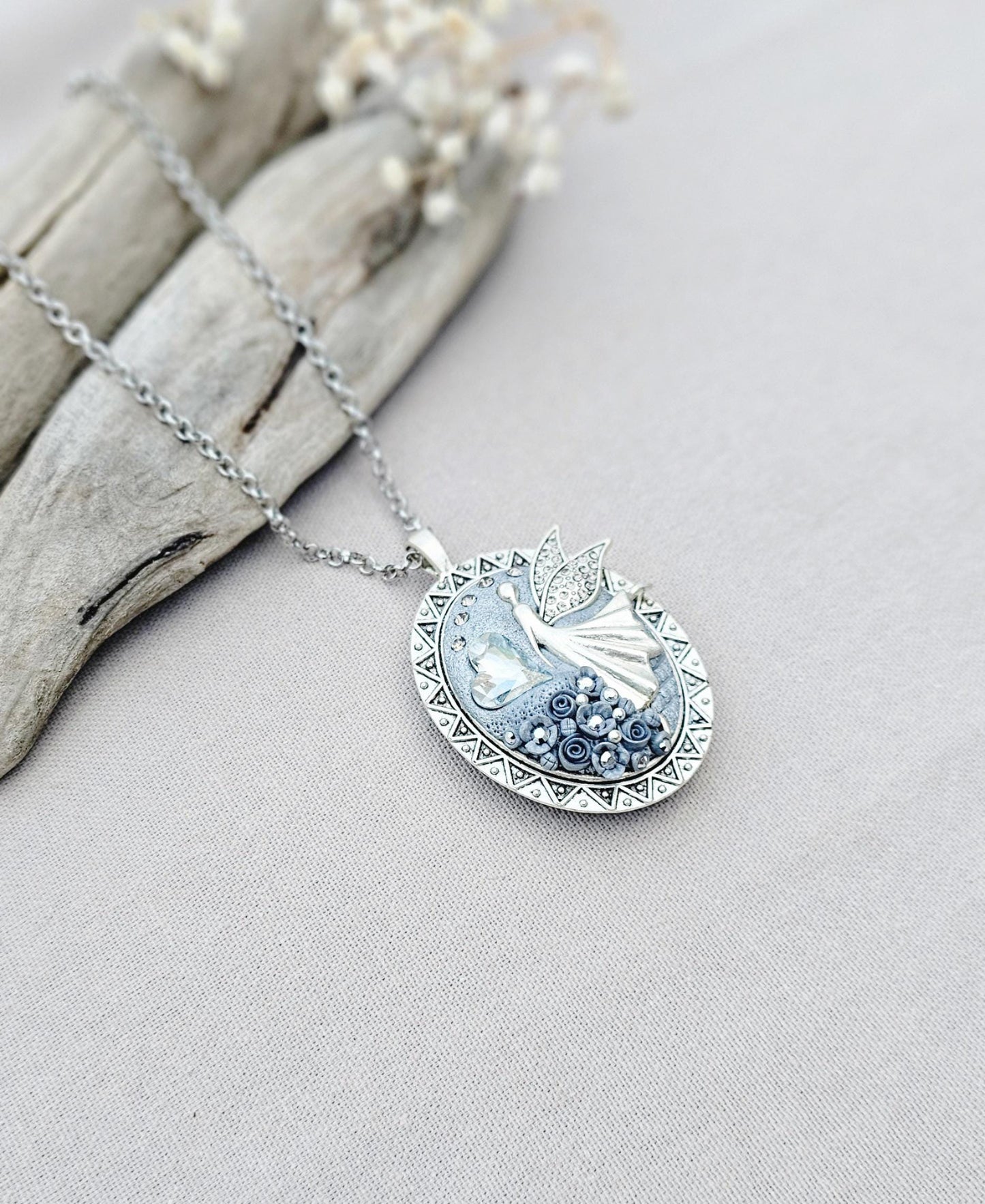 silver fairy pendant, gray floral locket, mystical jewelry, elegant necklace, fairy charm, crystal pendant, handcrafted accessory, unique fairy necklace, silver chain pendant, keepsake locket, photo locket, sophisticated charm, magical jewelry