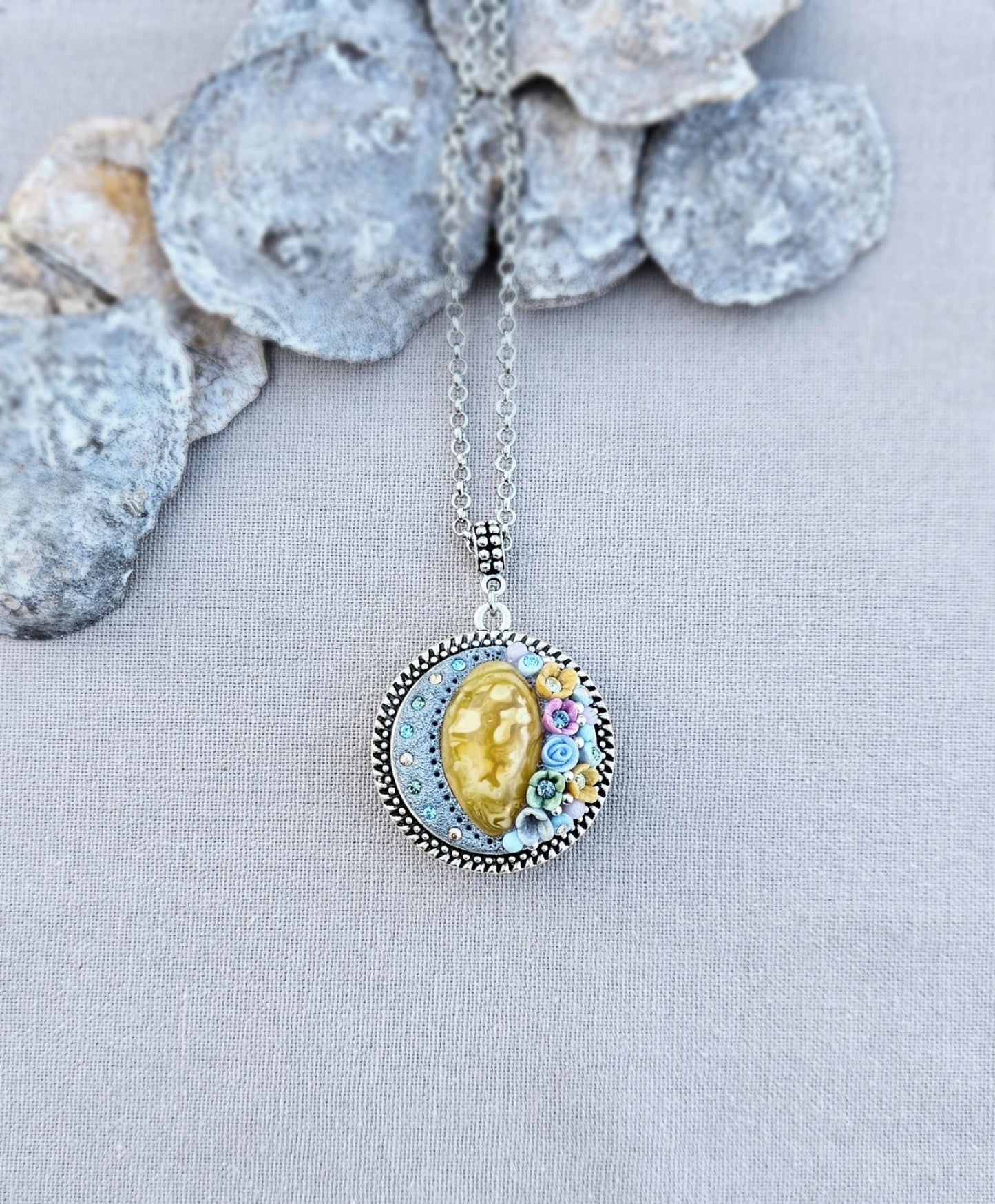Pendant locket with amber, handmade flowers from polymer clay. On the other side, there is a locket with a heart that opens, inside which you can put a photo or a scent. A great gift for a loved one, or for yourself as a protective amulet.
