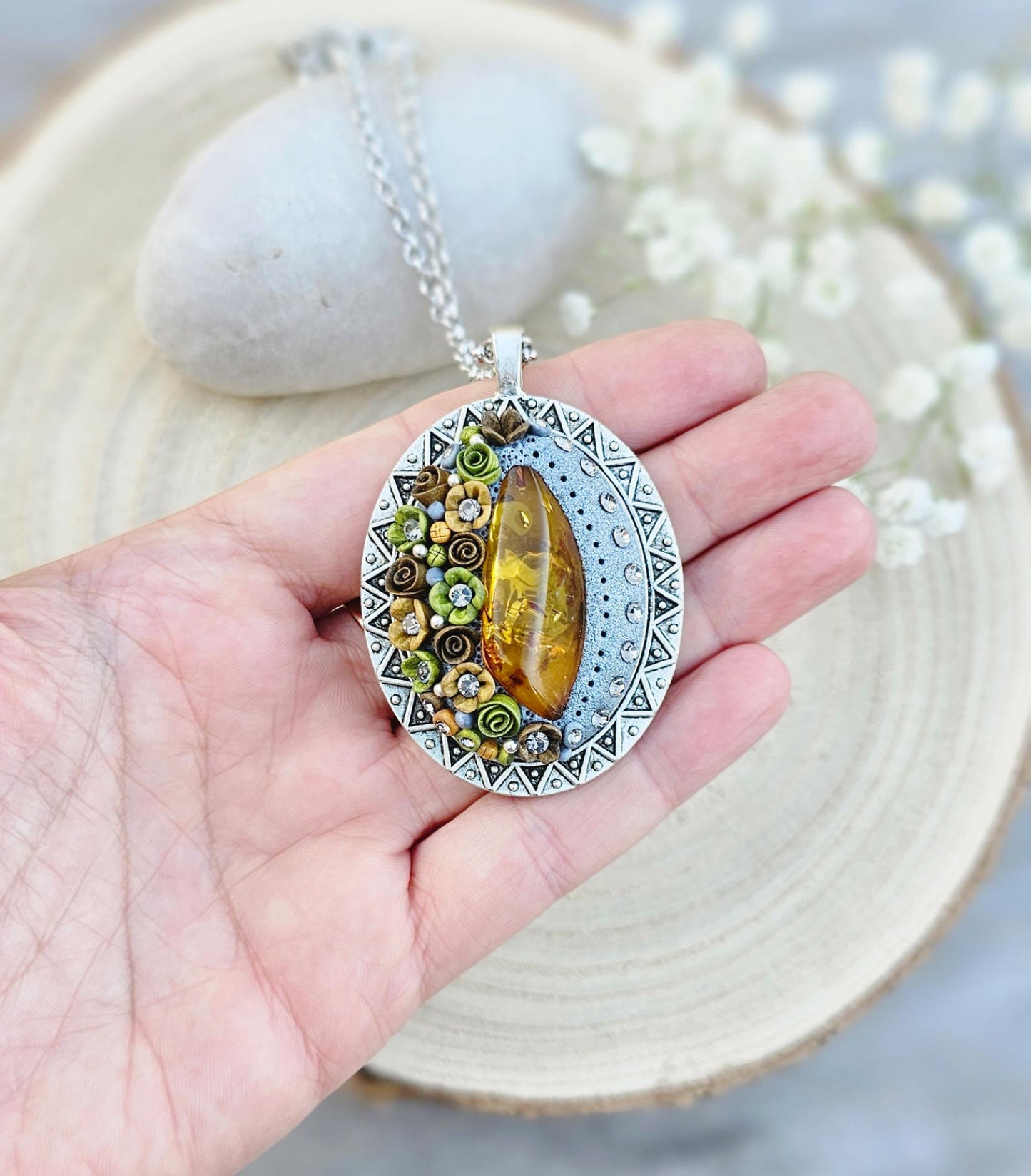 Pendant locket with amber, handmade flowers from polymer clay. On the other side, there is a locket with a heart that opens, inside which you can put a photo or a scent. A great gift for a loved one, or for yourself as a protective amulet.