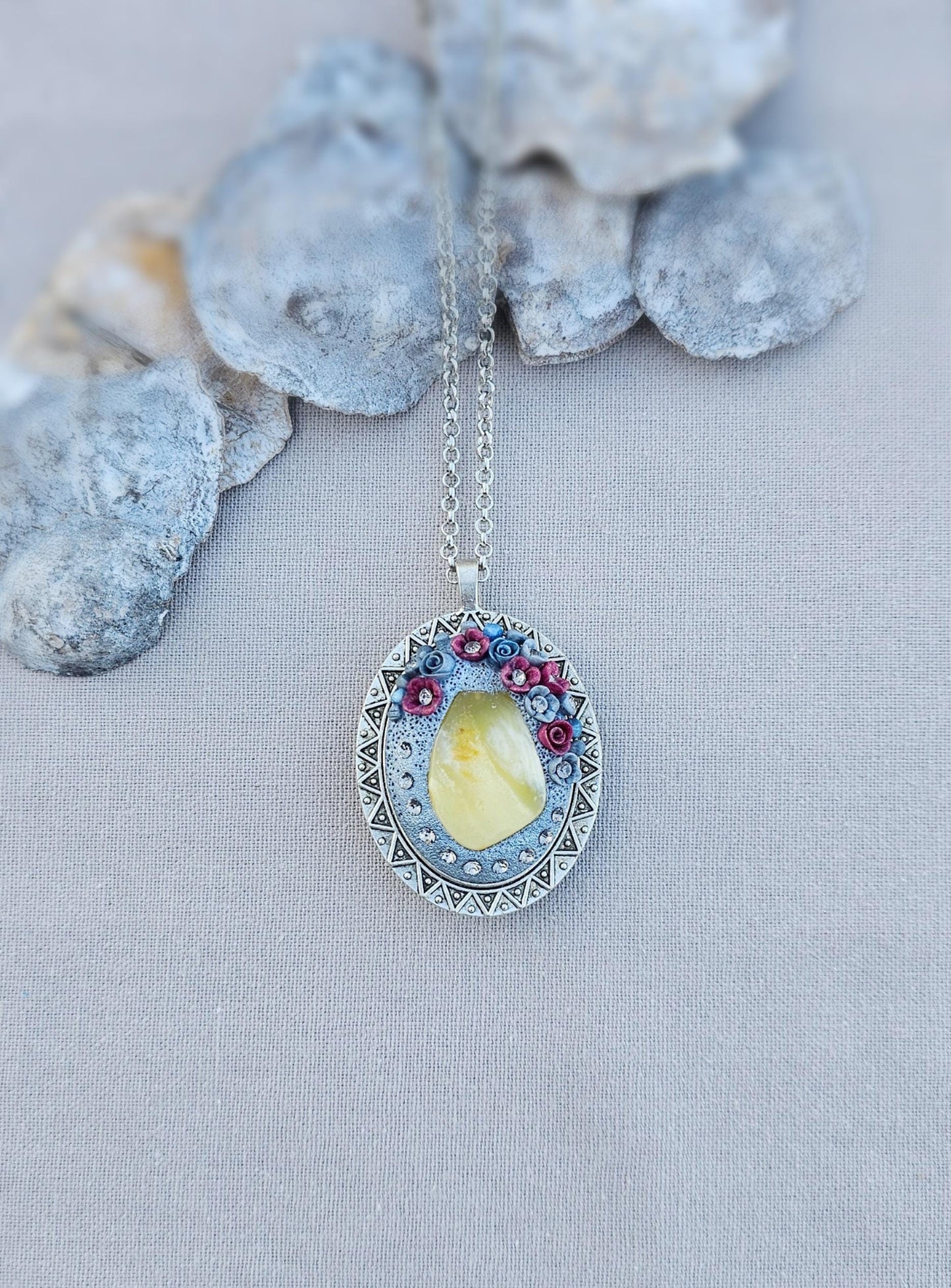 Pendant locket with amber, handmade flowers from polymer clay. On the other side, there is a locket with a heart that opens, inside which you can put a photo or a scent. A great gift for a loved one, or for yourself as a protective amulet.