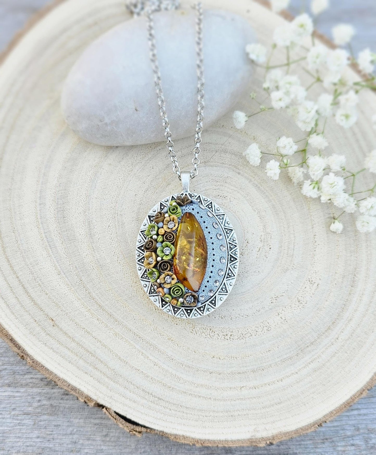 Pendant locket with amber, handmade flowers from polymer clay. On the other side, there is a locket with a heart that opens, inside which you can put a photo or a scent. A great gift for a loved one, or for yourself as a protective amulet.