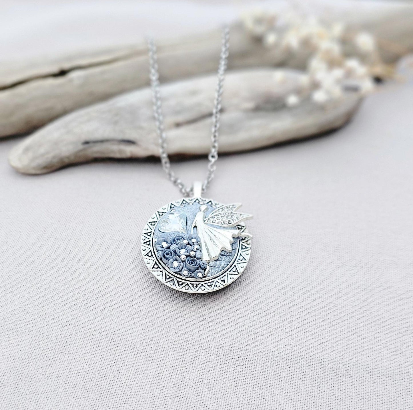 silver fairy pendant, gray floral locket, mystical jewelry, elegant necklace, fairy charm, crystal pendant, handcrafted accessory, unique fairy necklace, silver chain pendant, keepsake locket, photo locket, sophisticated charm, magical jewelry