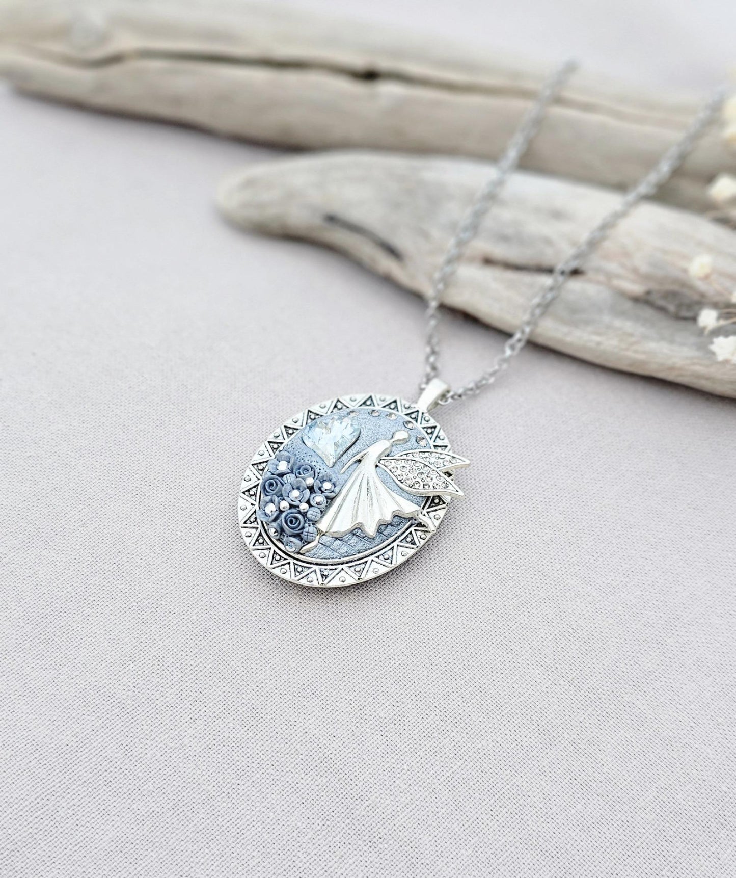 silver fairy pendant, gray floral locket, mystical jewelry, elegant necklace, fairy charm, crystal pendant, handcrafted accessory, unique fairy necklace, silver chain pendant, keepsake locket, photo locket, sophisticated charm, magical jewelry