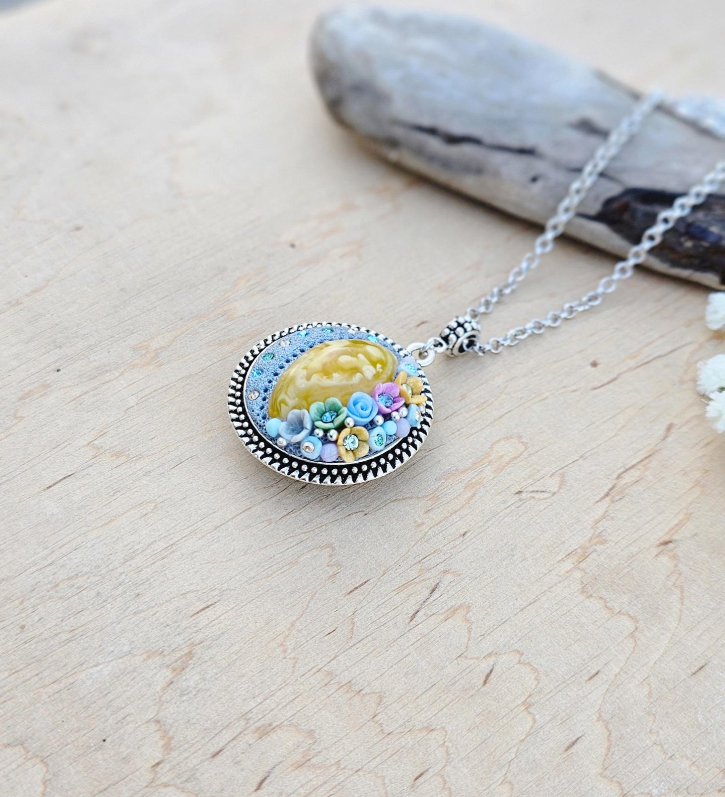 Pendant locket with amber, handmade flowers from polymer clay. On the other side, there is a locket with a heart that opens, inside which you can put a photo or a scent. A great gift for a loved one, or for yourself as a protective amulet.
