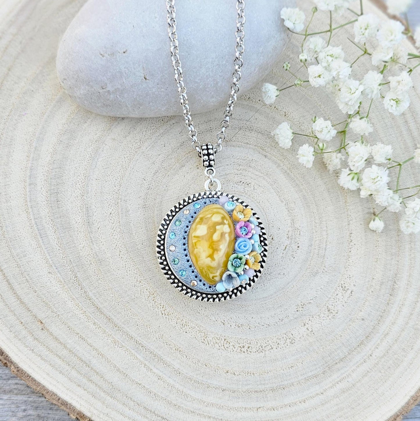 Pendant locket with amber, handmade flowers from polymer clay. On the other side, there is a locket with a heart that opens, inside which you can put a photo or a scent. A great gift for a loved one, or for yourself as a protective amulet.