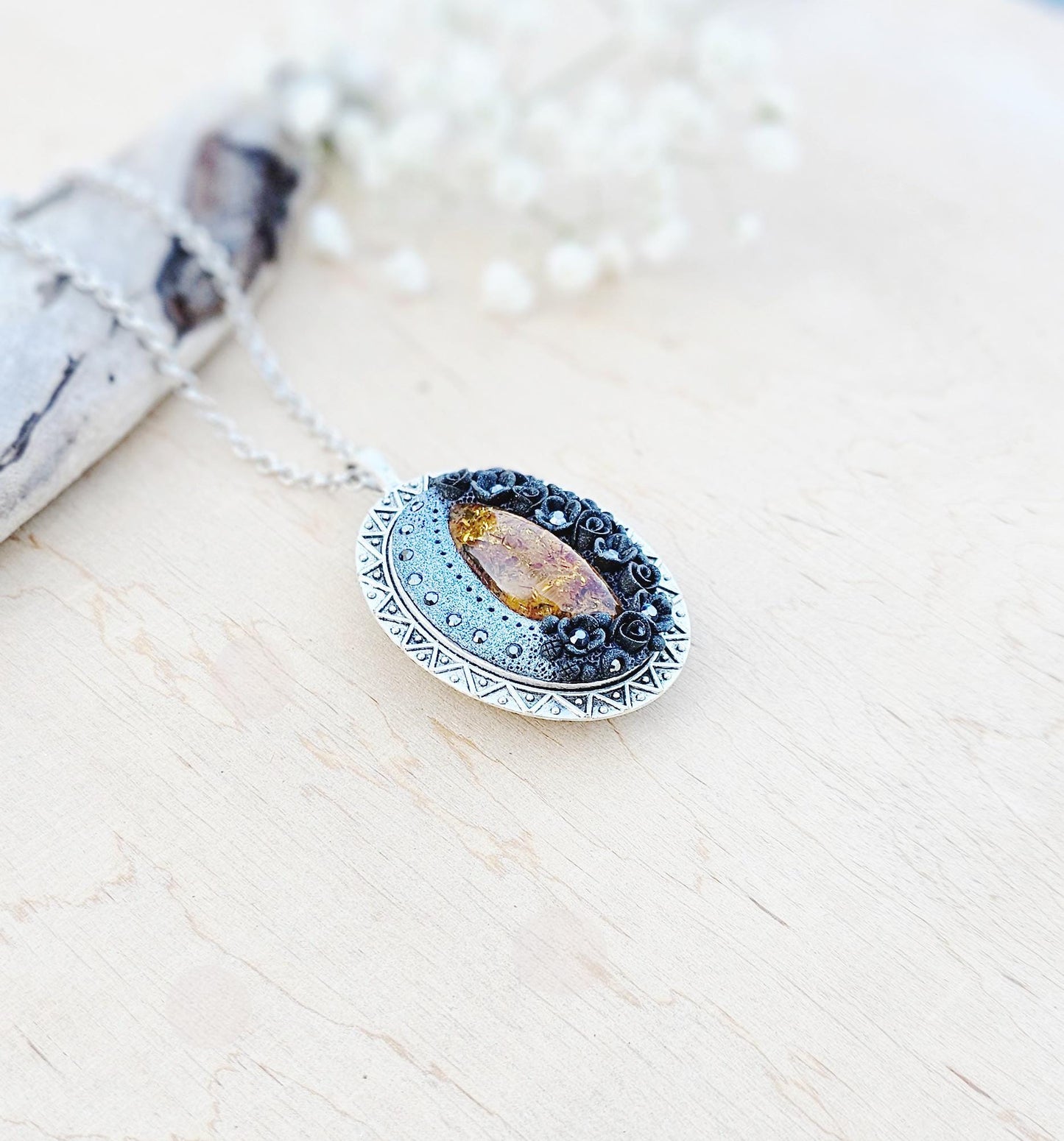 Pendant locket with amber, handmade flowers from polymer clay. On the other side, there is a locket with a heart that opens, inside which you can put a photo or a scent. A great gift for a loved one, or for yourself as a protective amulet.