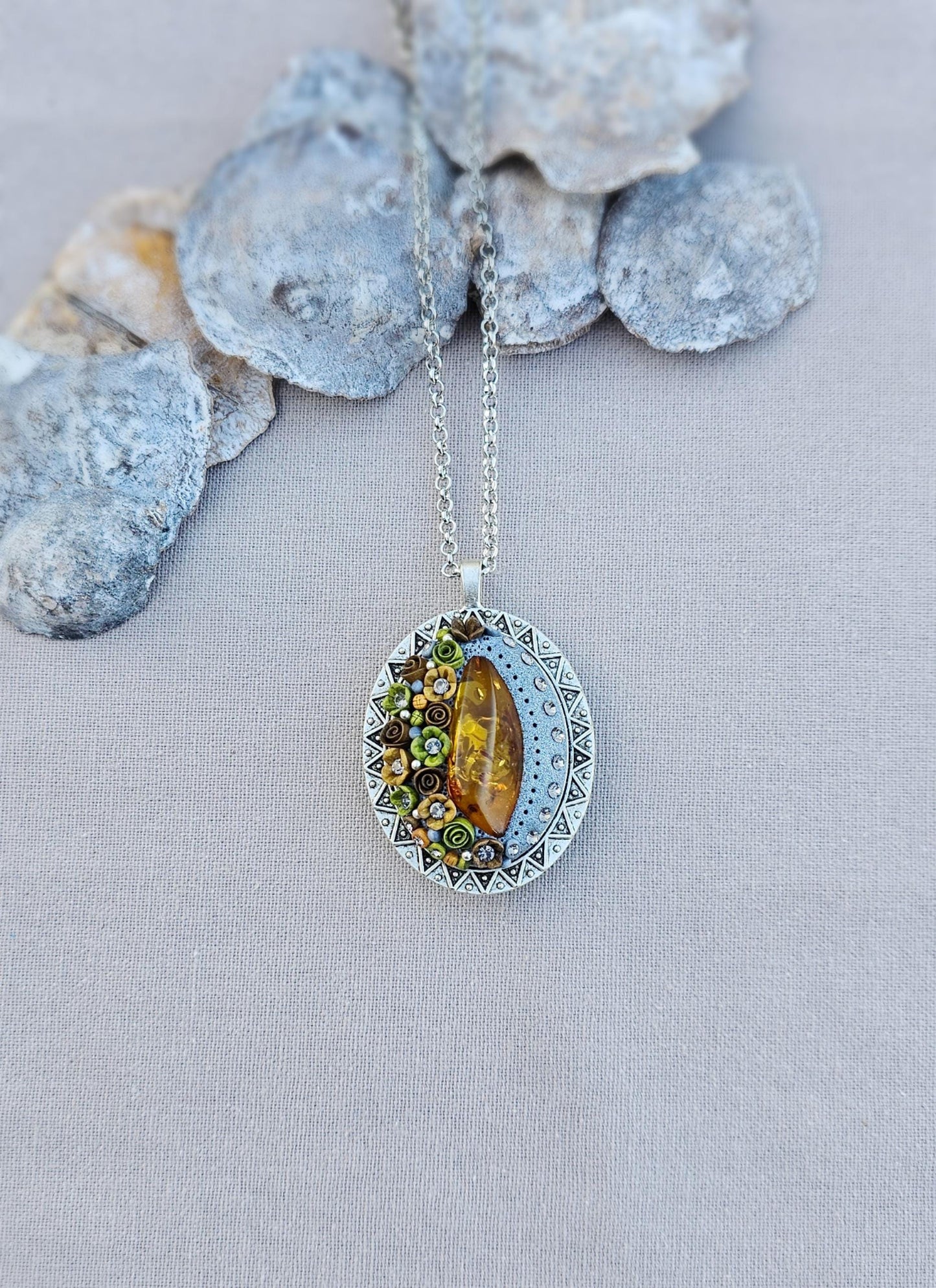 Pendant locket with amber, handmade flowers from polymer clay. On the other side, there is a locket with a heart that opens, inside which you can put a photo or a scent. A great gift for a loved one, or for yourself as a protective amulet.