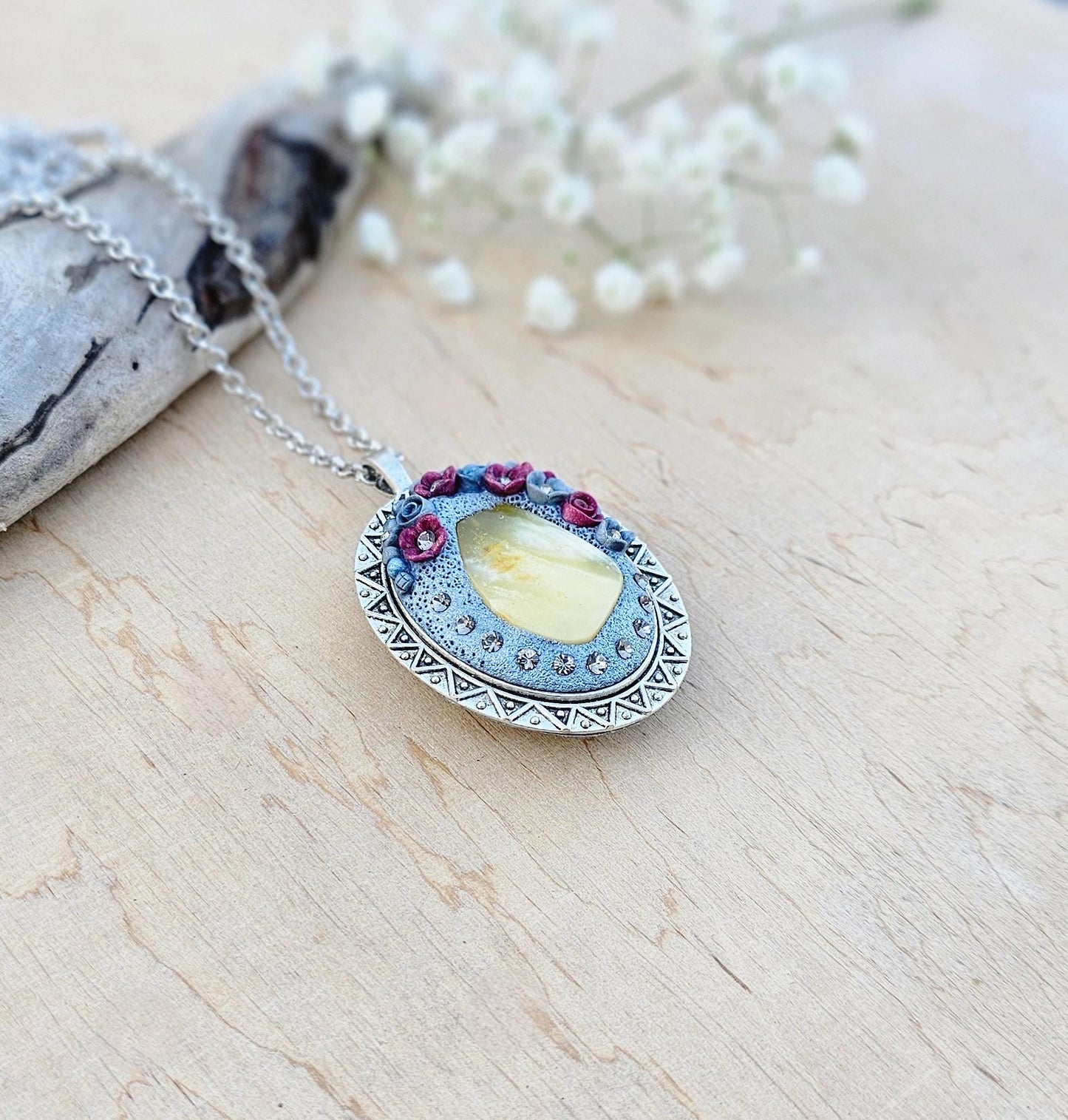 Pendant locket with amber, handmade flowers from polymer clay. On the other side, there is a locket with a heart that opens, inside which you can put a photo or a scent. A great gift for a loved one, or for yourself as a protective amulet.