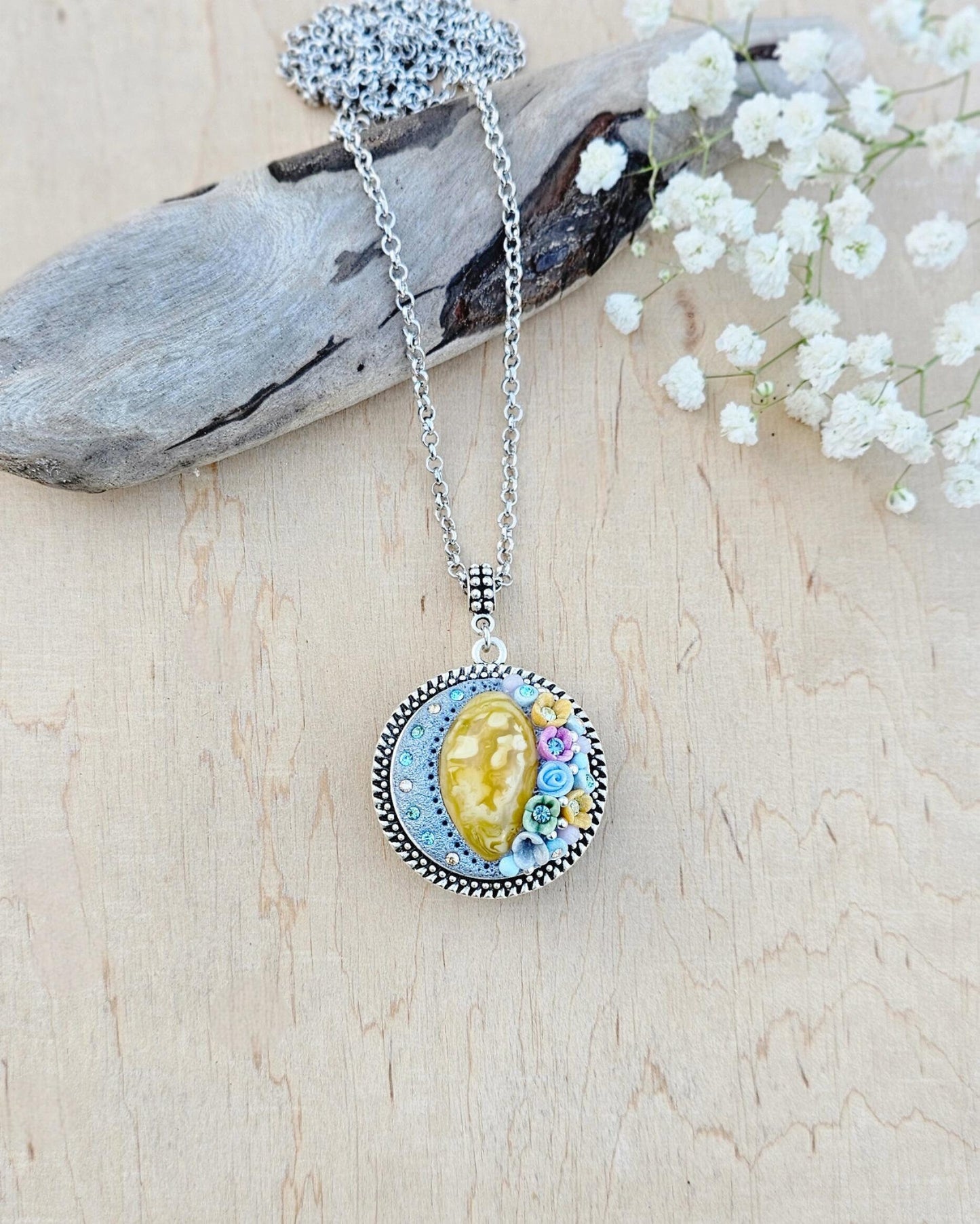 Pendant locket with amber, handmade flowers from polymer clay. On the other side, there is a locket with a heart that opens, inside which you can put a photo or a scent. A great gift for a loved one, or for yourself as a protective amulet.