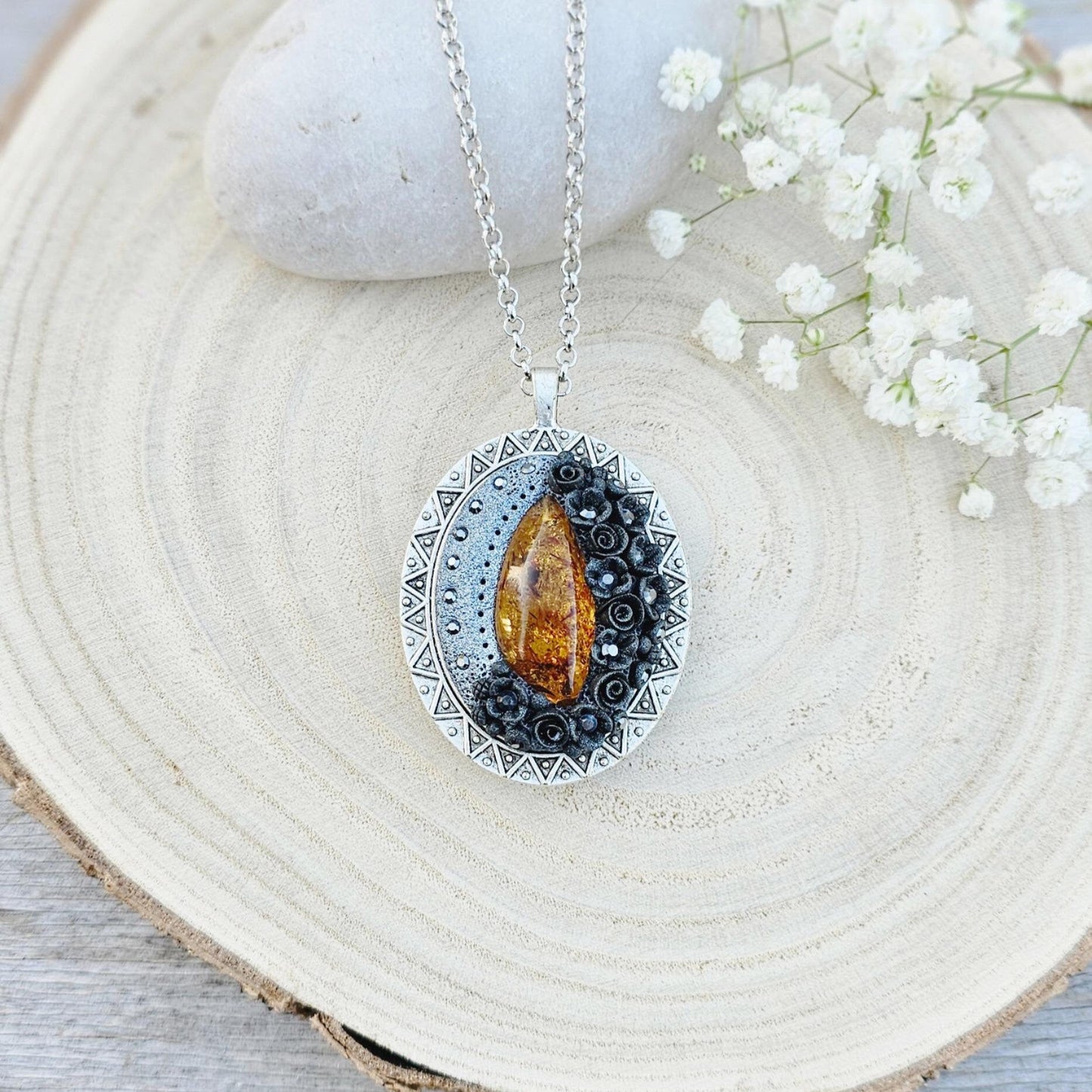 Pendant locket with amber, handmade flowers from polymer clay. On the other side, there is a locket with a heart that opens, inside which you can put a photo or a scent. A great gift for a loved one, or for yourself as a protective amulet.