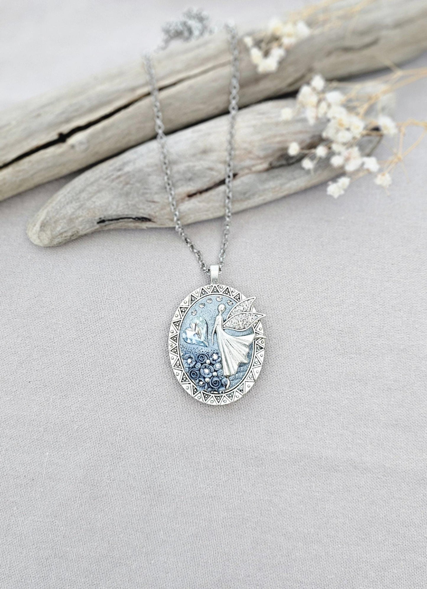 silver fairy pendant, gray floral locket, mystical jewelry, elegant necklace, fairy charm, crystal pendant, handcrafted accessory, unique fairy necklace, silver chain pendant, keepsake locket, photo locket, sophisticated charm, magical jewelry