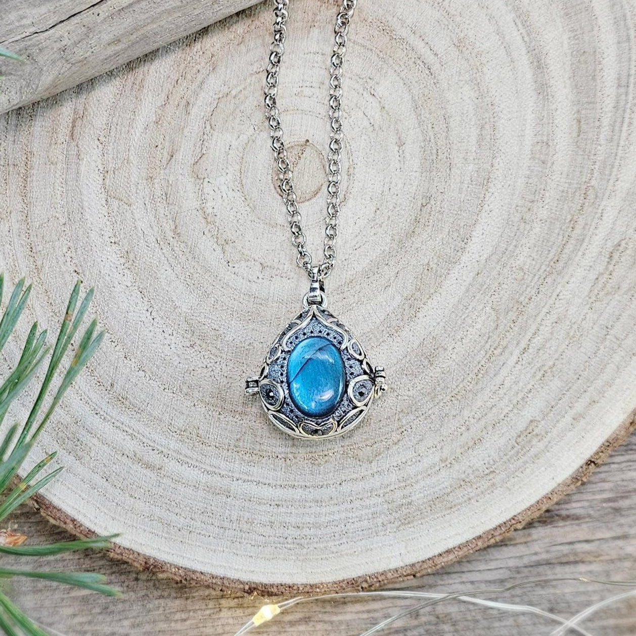 This exquisite handcrafted locket pendant features a mesmerizing Labradorite stone set in a silver-toned metal frame with polymer clay accents.