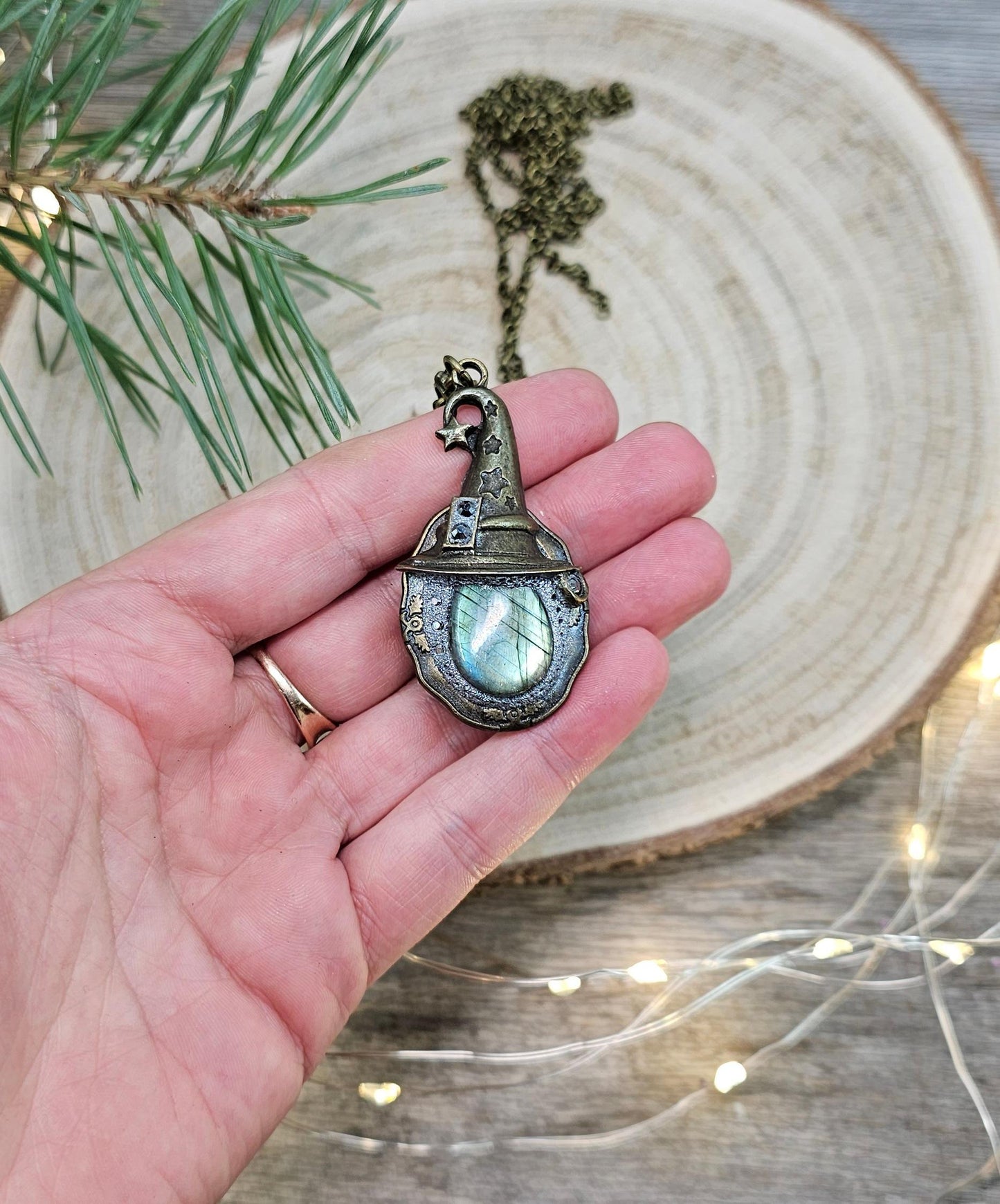 A magical pendant featuring a wizard’s hat, a stunning labradorite stone, and a hidden locket on the other side. Say “Abracadabra” and let your wishes come true!