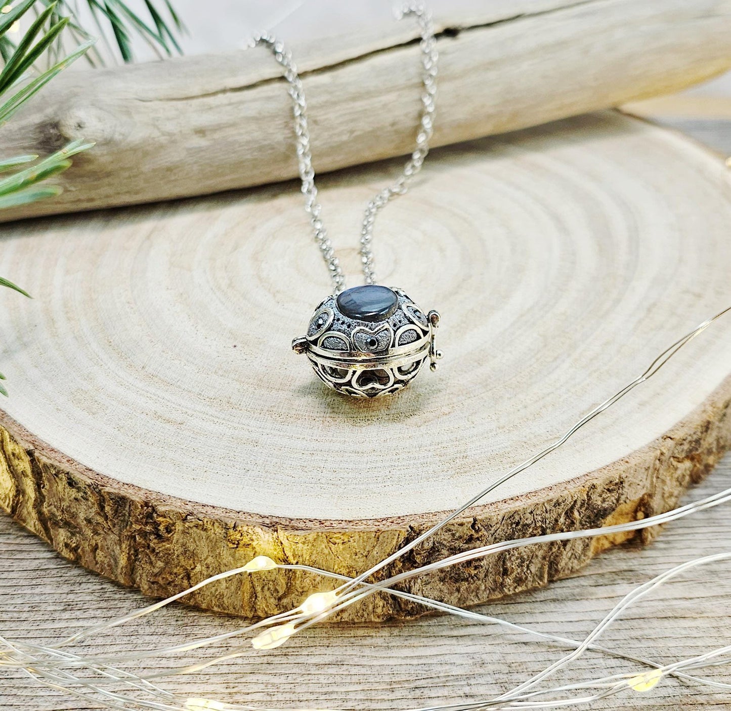 This exquisite handcrafted locket pendant features a mesmerizing Labradorite stone set in a silver-toned metal frame with polymer clay accents.