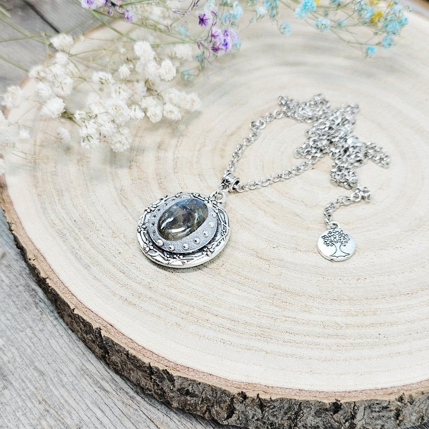 Silver vintage-style pendant necklace featuring a mesmerizing blue flash labradorite stone, set in an ornate medallion frame with intricate details.