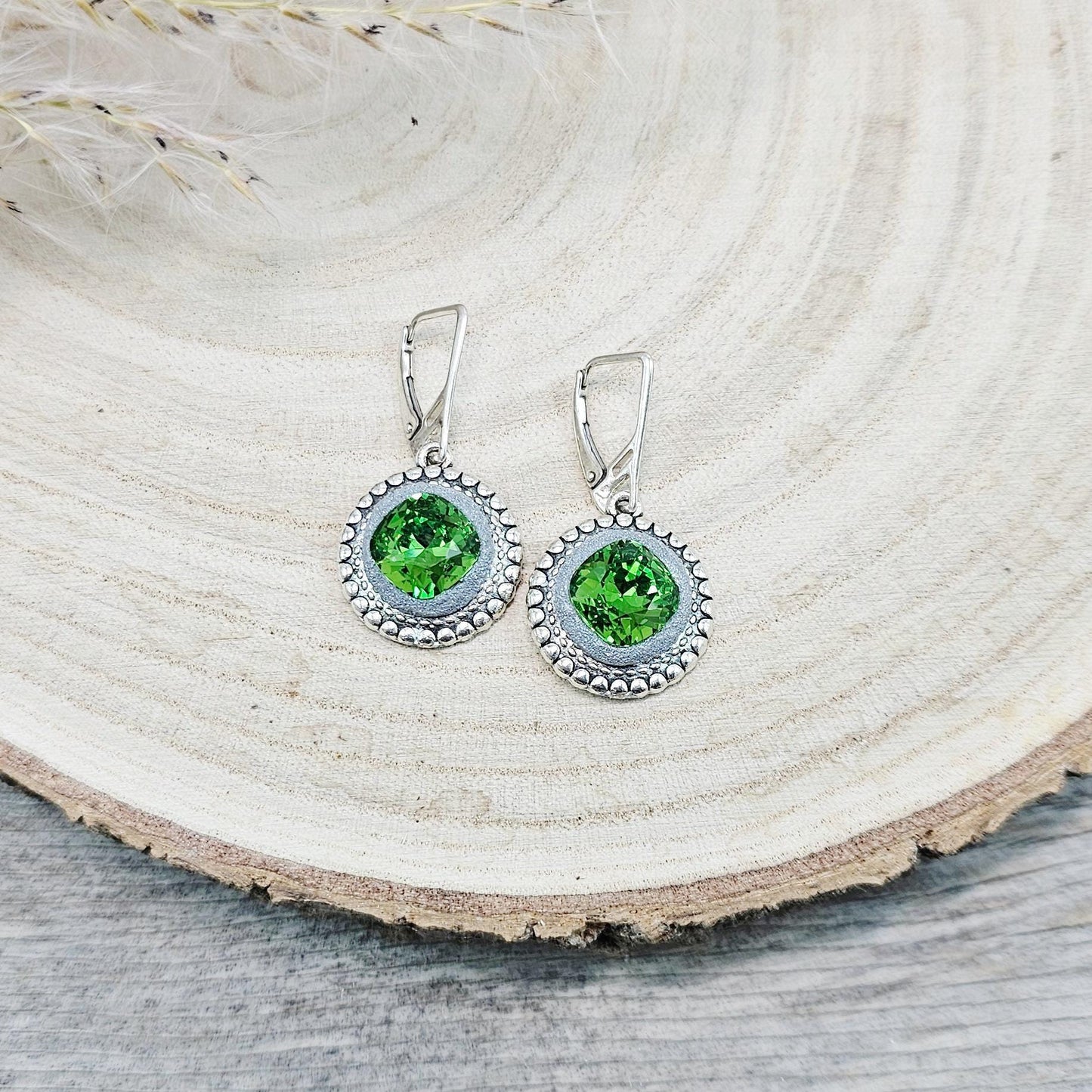 Elegant dangle earrings with sparkling green crystals set in metal frames with polymer clay details. Silver hooks. Packaged in a paper gift box. A perfect accessory for any occasion, adding a touch of brilliance and sophistication
