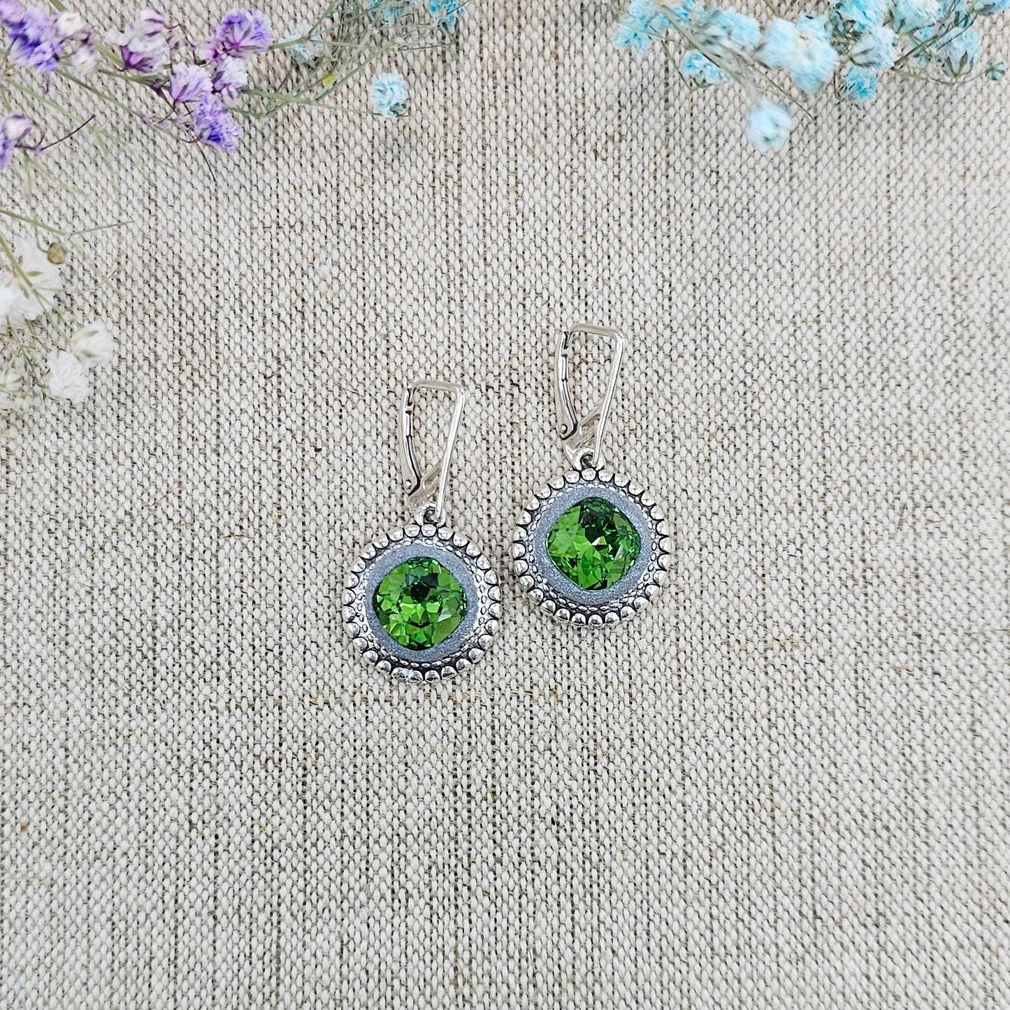 Elegant dangle earrings with sparkling green crystals set in metal frames with polymer clay details. Silver hooks. Packaged in a paper gift box. A perfect accessory for any occasion, adding a touch of brilliance and sophistication