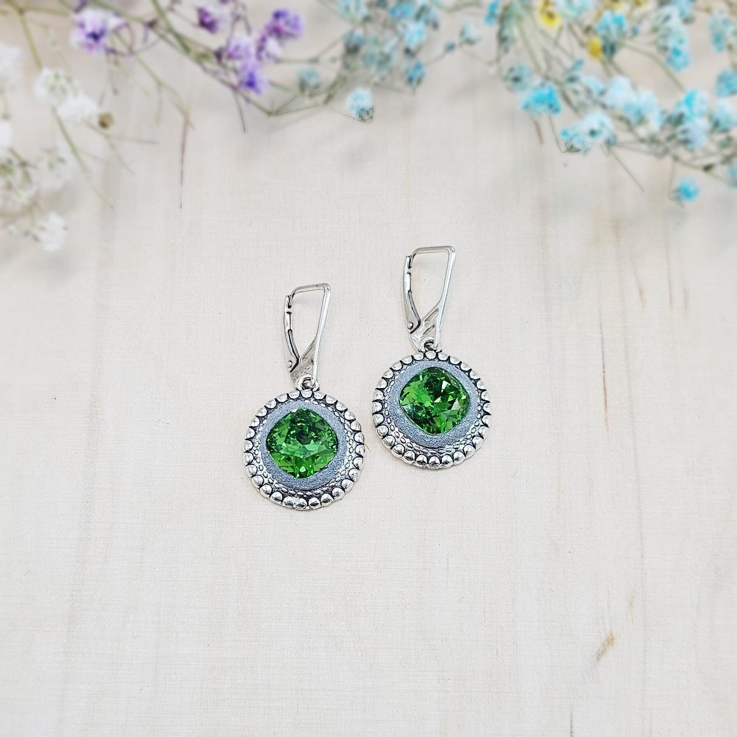 Elegant dangle earrings with sparkling green crystals set in metal frames with polymer clay details. Silver hooks. Packaged in a paper gift box. A perfect accessory for any occasion, adding a touch of brilliance and sophistication
