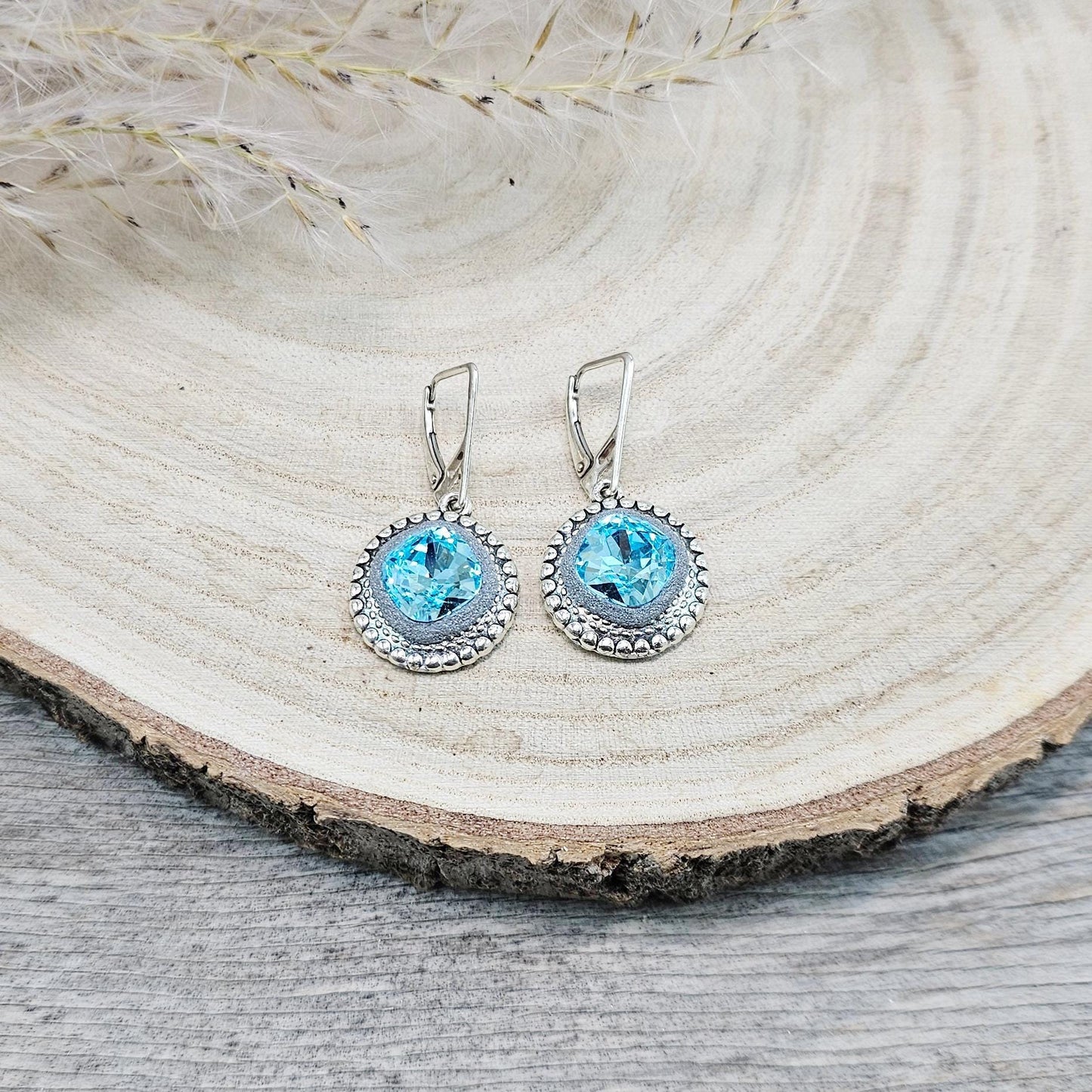 Elegant dangle earrings with sparkling light blue color crystals set in metal frames with polymer clay details. Silver hooks. Packaged in a paper gift box. A perfect accessory for any occasion, adding a touch of brilliance and sophistication