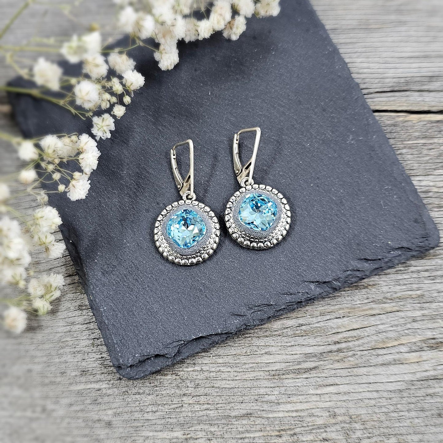 Elegant dangle earrings with sparkling light blue color crystals set in metal frames with polymer clay details. Silver hooks. Packaged in a paper gift box. A perfect accessory for any occasion, adding a touch of brilliance and sophistication