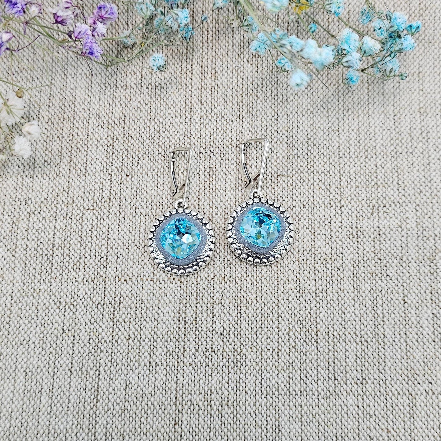 Elegant dangle earrings with sparkling light blue color crystals set in metal frames with polymer clay details. Silver hooks. Packaged in a paper gift box. A perfect accessory for any occasion, adding a touch of brilliance and sophistication