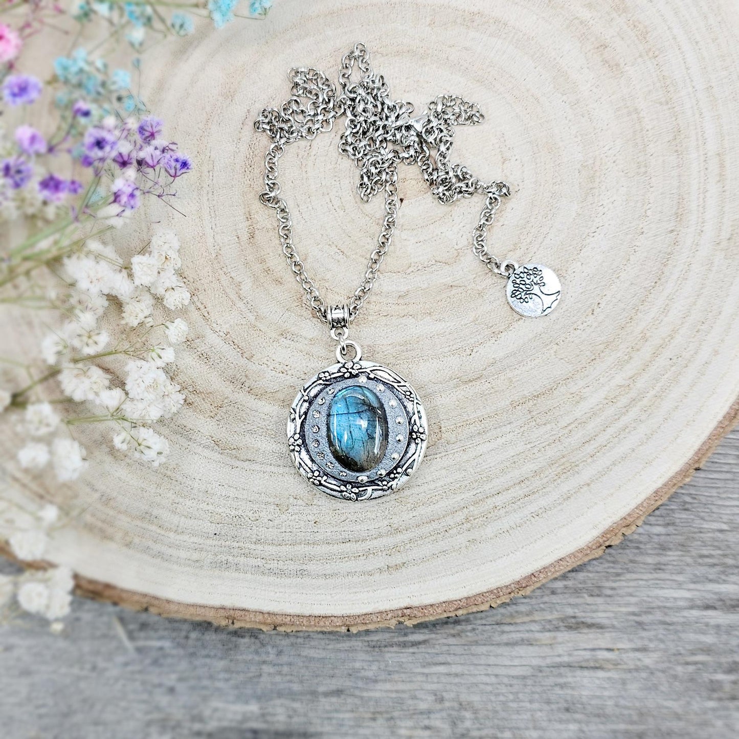 Silver vintage-style pendant necklace featuring a mesmerizing blue flash labradorite stone, set in an ornate medallion frame with intricate details.