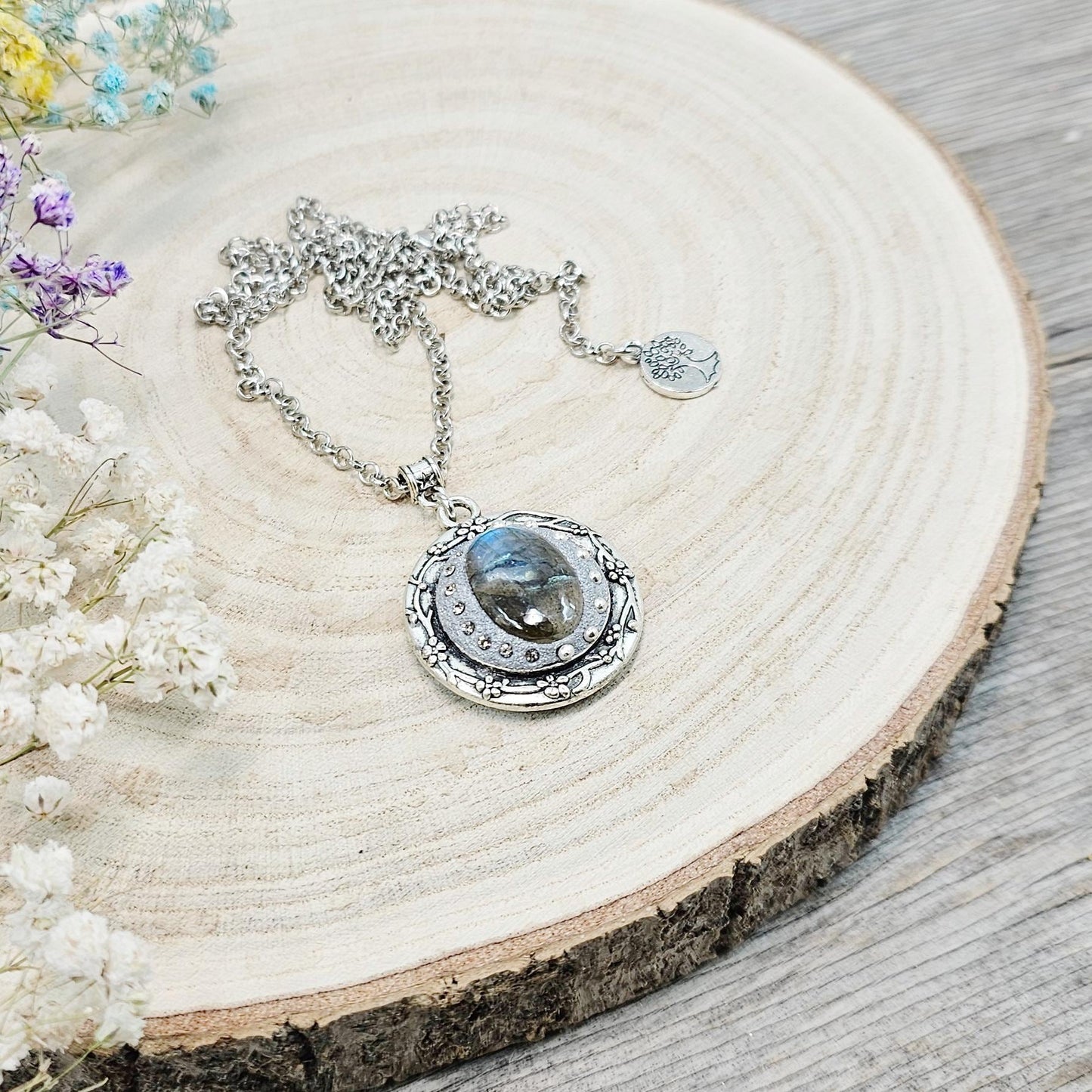 Silver vintage-style pendant necklace featuring a mesmerizing blue flash labradorite stone, set in an ornate medallion frame with intricate details.