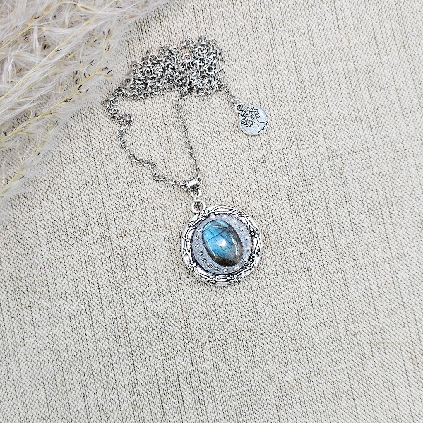 Silver vintage-style pendant necklace featuring a mesmerizing blue flash labradorite stone, set in an ornate medallion frame with intricate details.