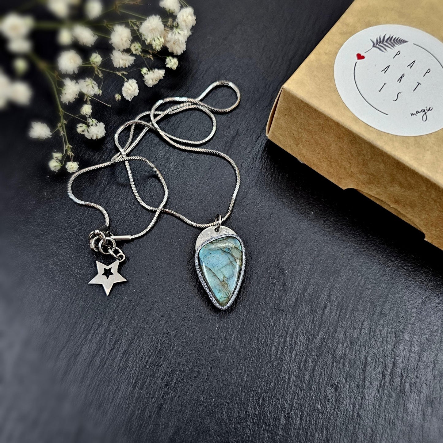 Mystical labradorite pendant with deep blue flash, presented next to a kraft jewelry box. Gift-ready magical necklace.