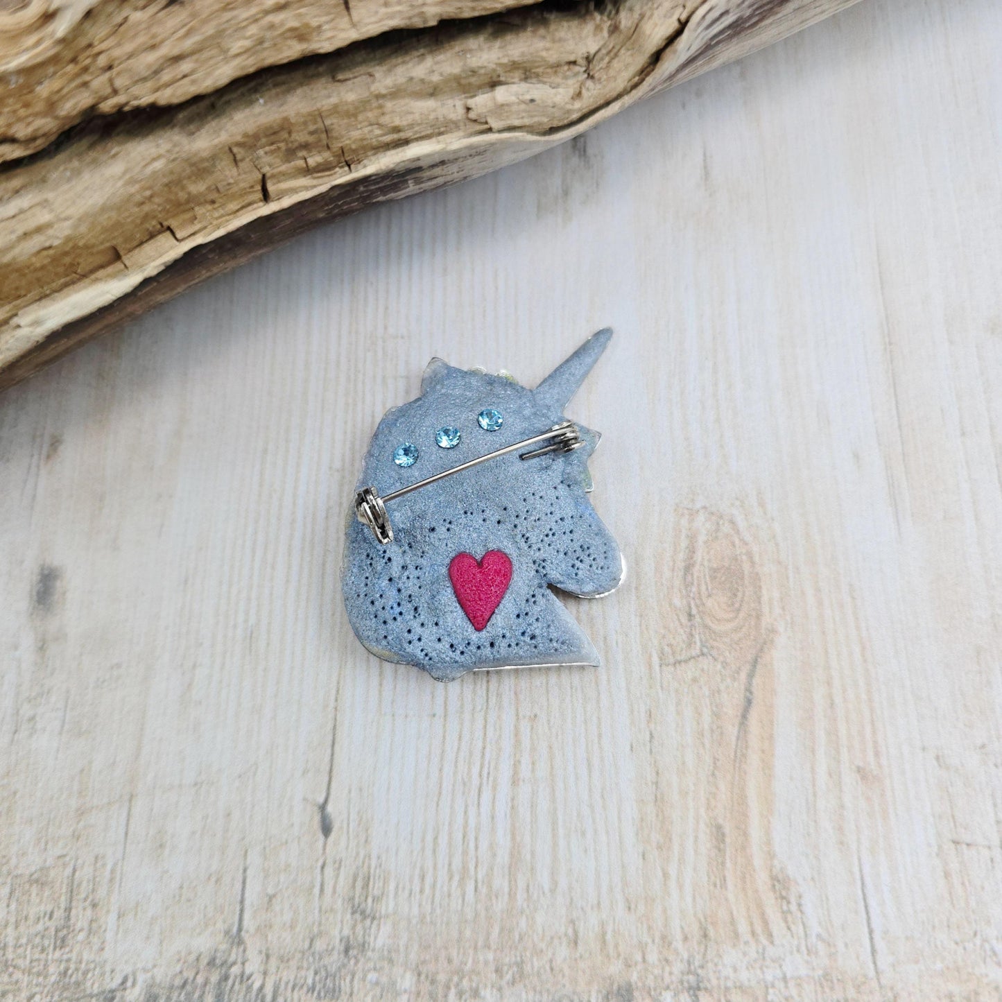 Handmade unicorn brooch featuring a shimmering labradorite, crafted from polymer clay with stainless steel backing – magical and unique fantasy jewelry.