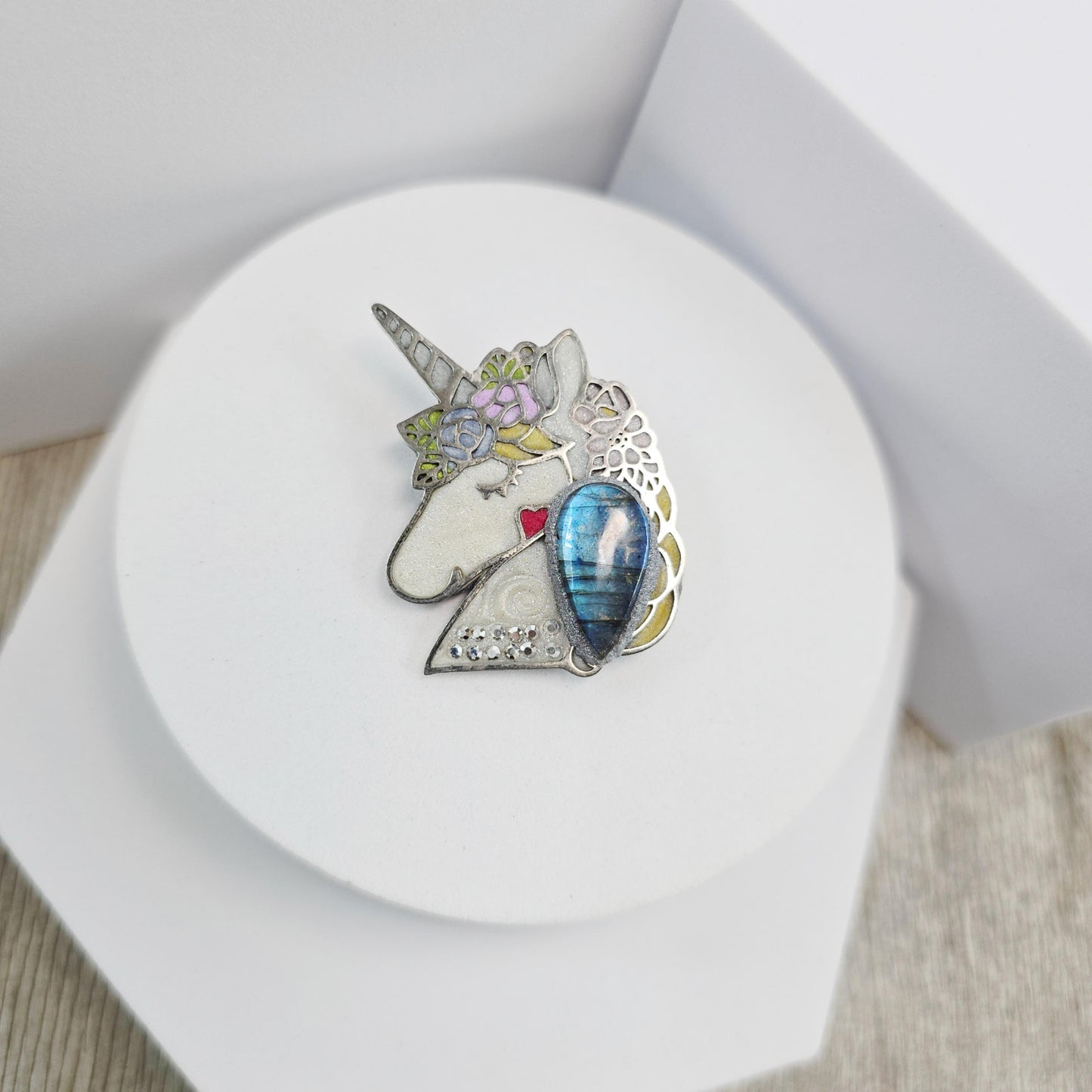 Handmade unicorn brooch featuring a shimmering labradorite, crafted from polymer clay with stainless steel backing – magical and unique fantasy jewelry.