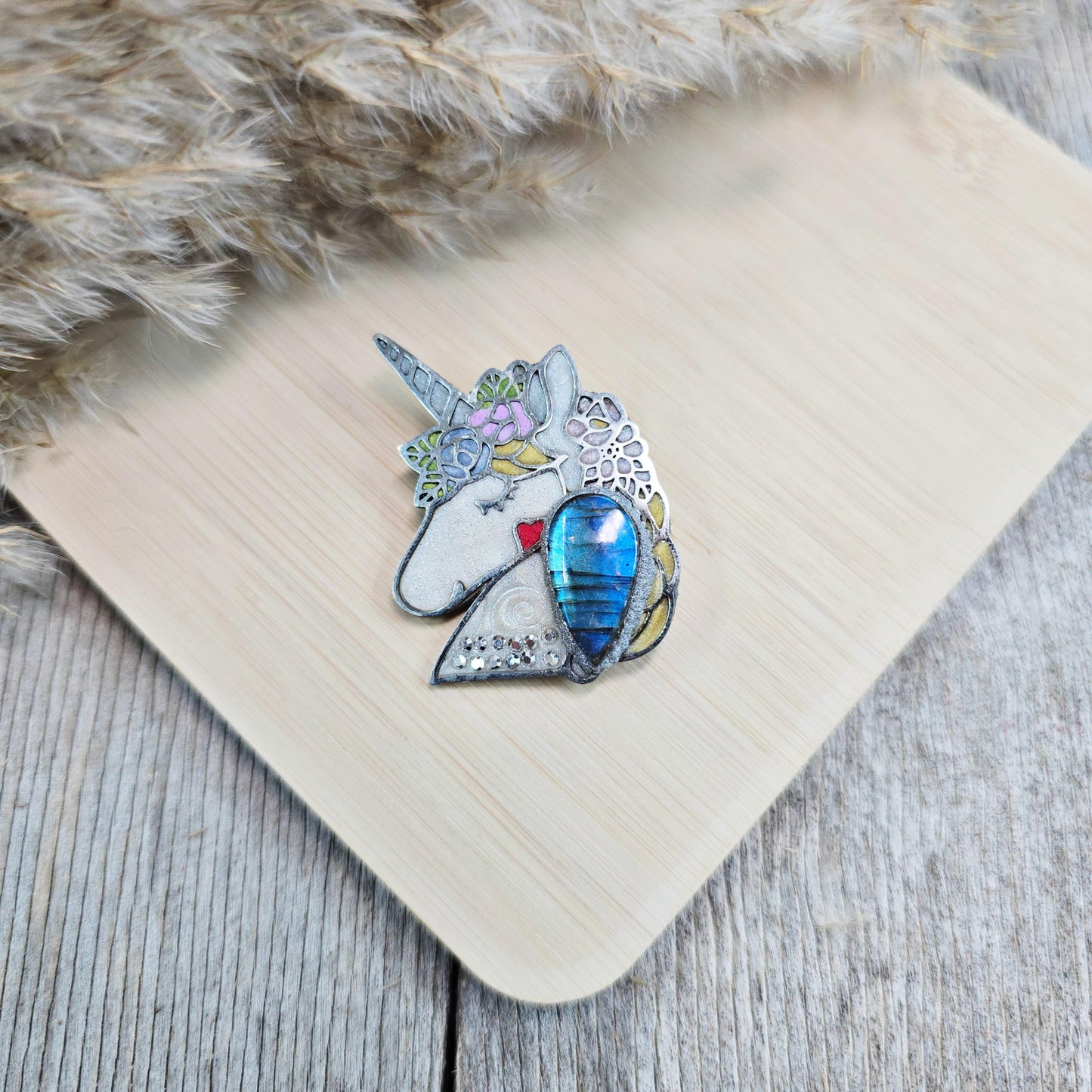Handmade unicorn brooch featuring a shimmering labradorite, crafted from polymer clay with stainless steel backing – magical and unique fantasy jewelry.
