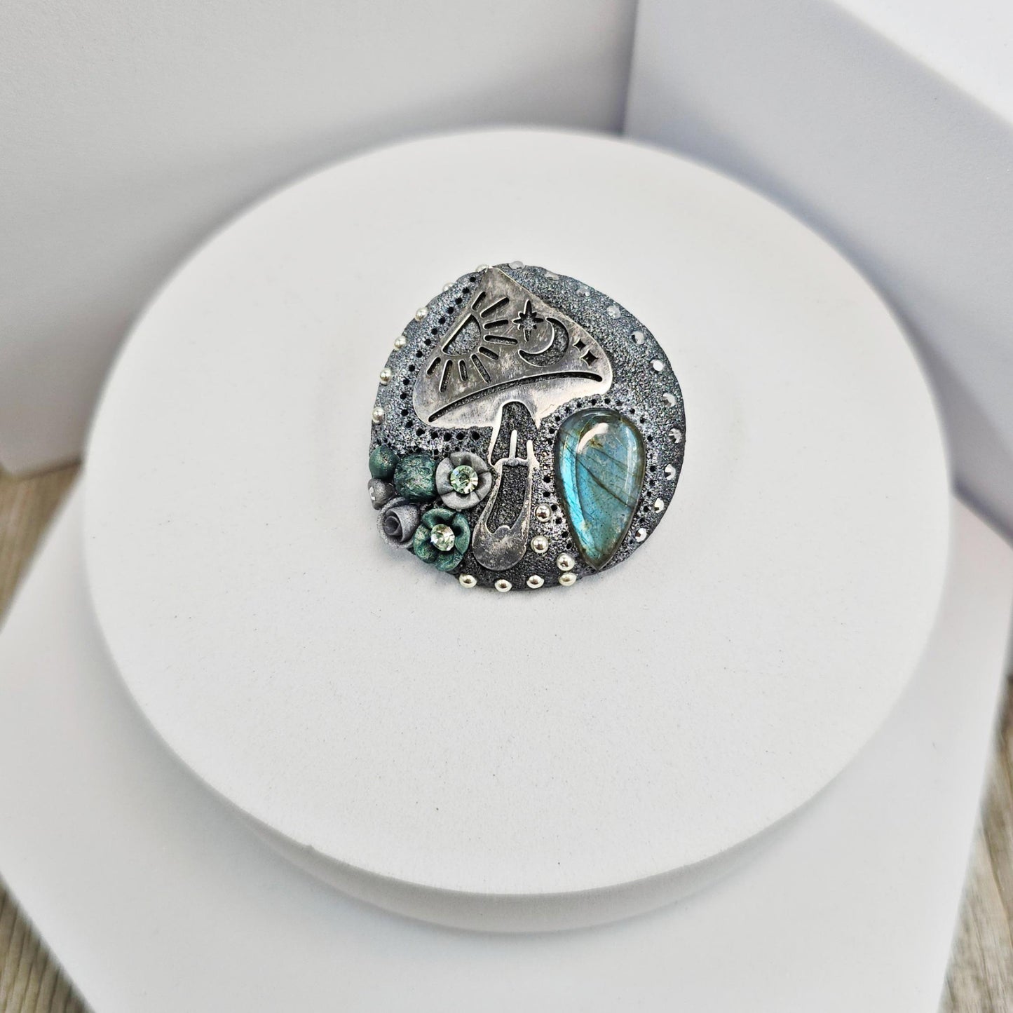 Handmade polymer clay brooch featuring a magical mushroom and a glowing labradorite stone, with stainless steel pin – forest-inspired mystical jewelry.