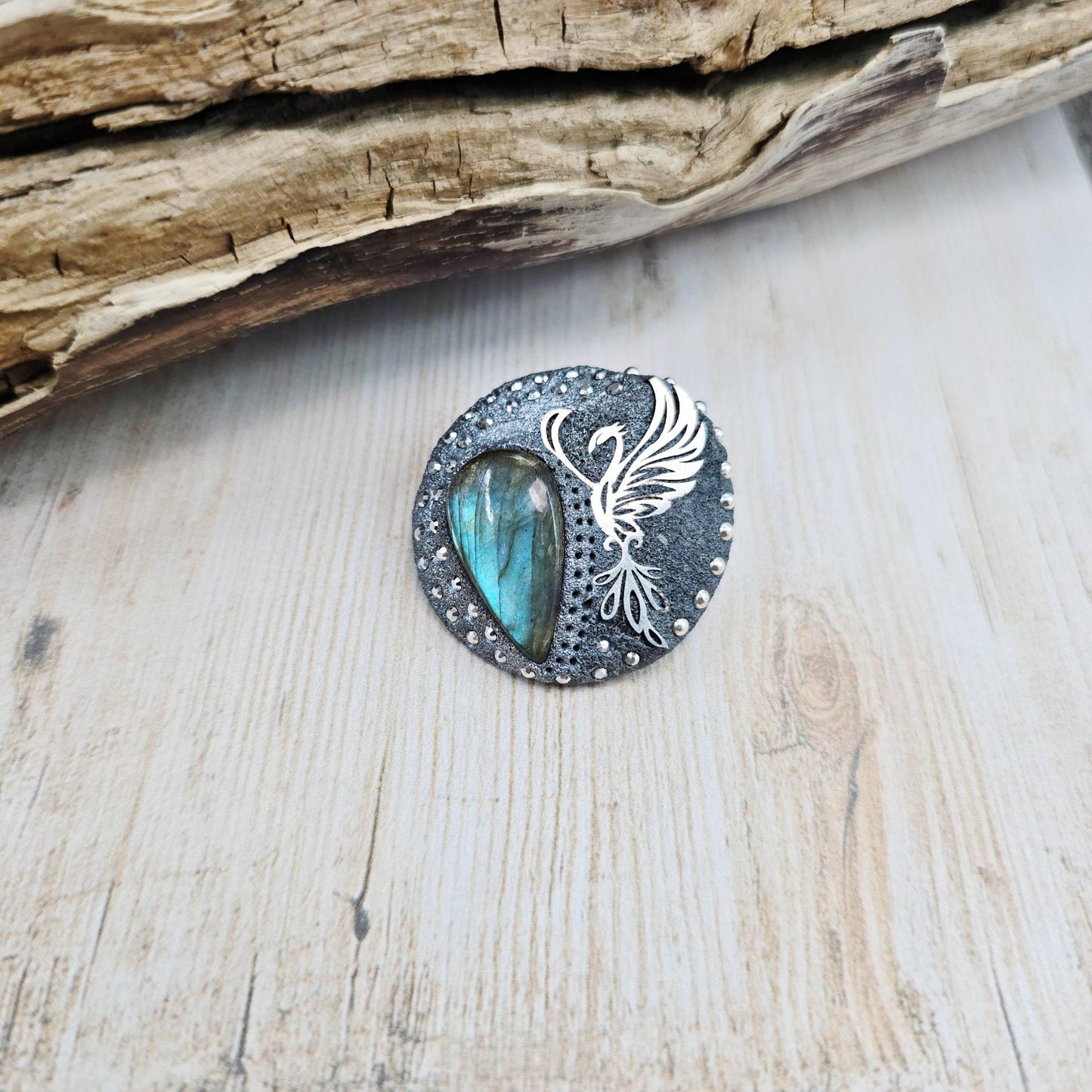Handmade phoenix brooch with natural labradorite – crafted from polymer clay and stainless steel. Unique mystical jewelry symbolizing rebirth and transformation.
