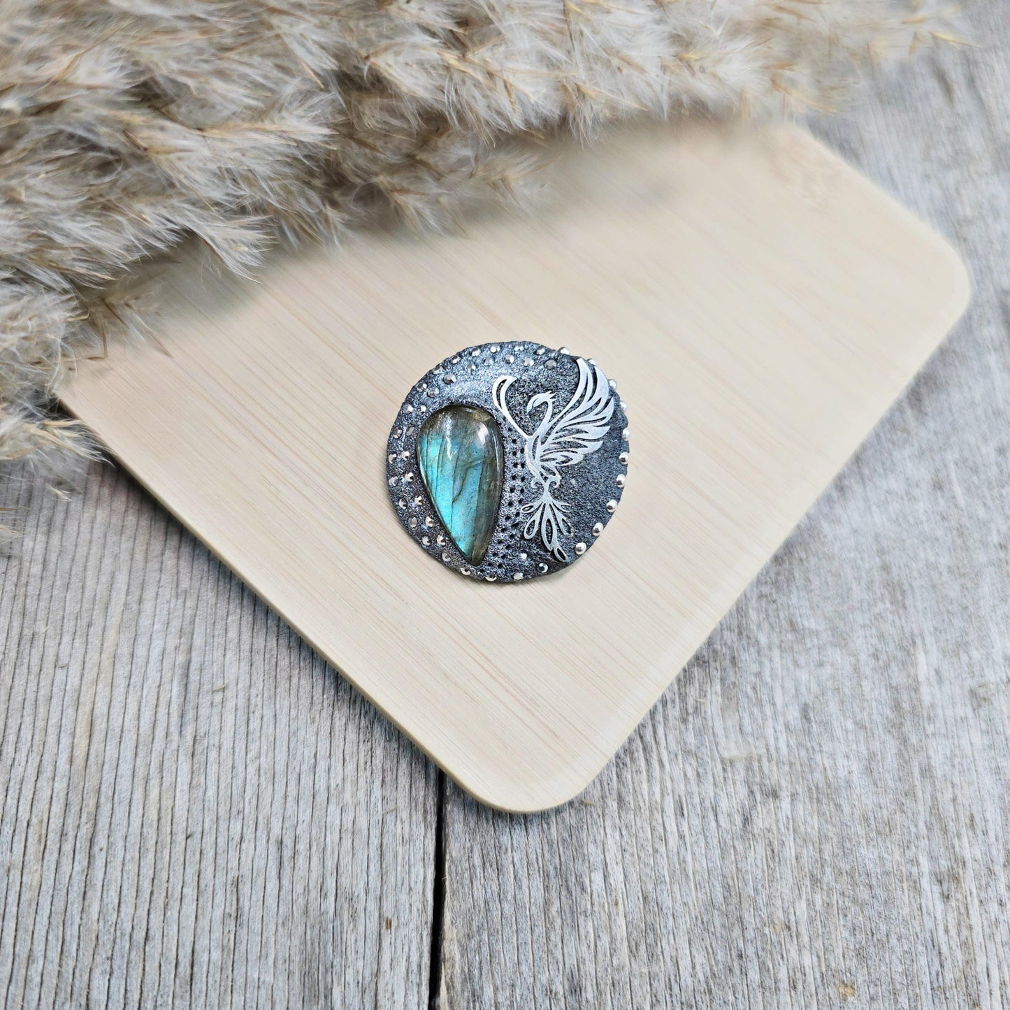 Handmade phoenix brooch with natural labradorite – crafted from polymer clay and stainless steel. Unique mystical jewelry symbolizing rebirth and transformation.
