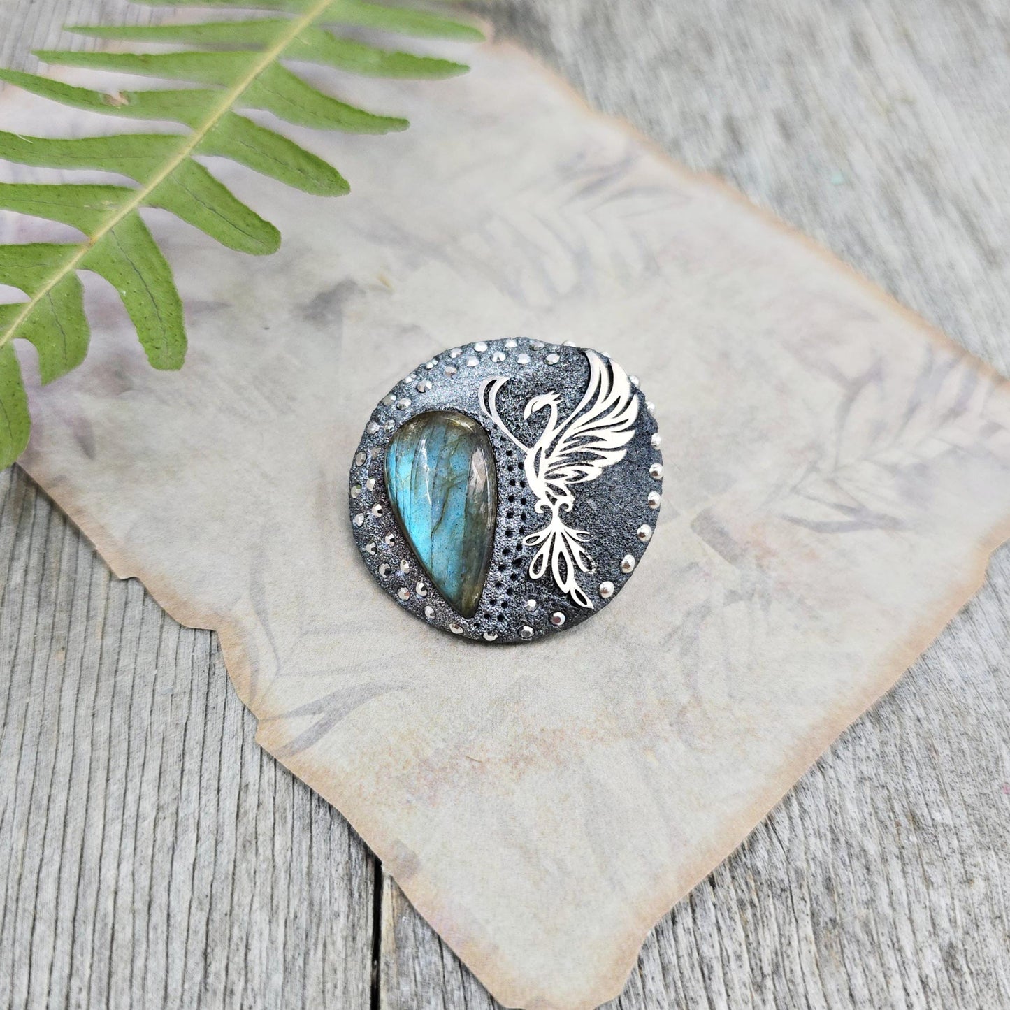 Handmade phoenix brooch with natural labradorite – crafted from polymer clay and stainless steel. Unique mystical jewelry symbolizing rebirth and transformation.