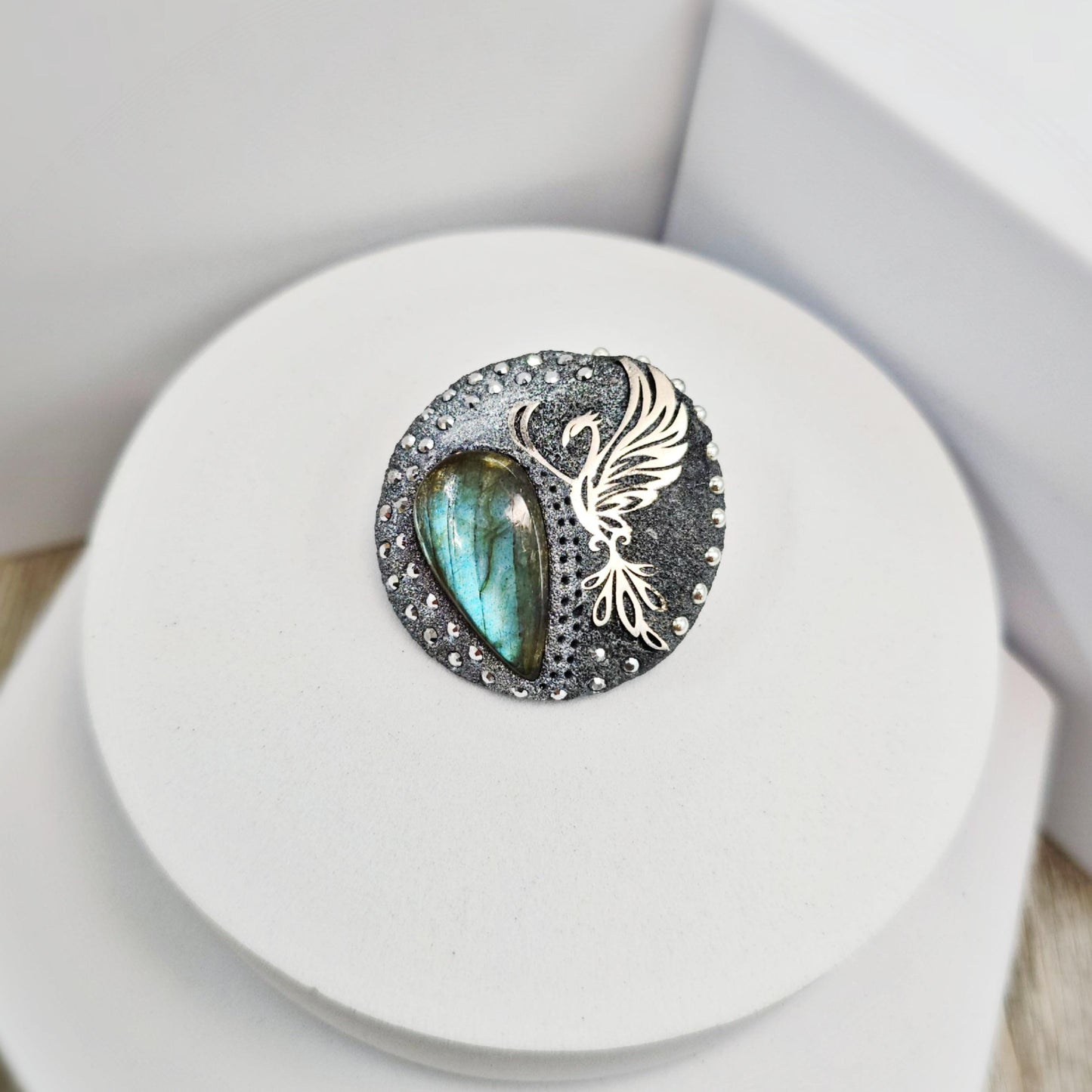 Handmade phoenix brooch with natural labradorite – crafted from polymer clay and stainless steel. Unique mystical jewelry symbolizing rebirth and transformation.