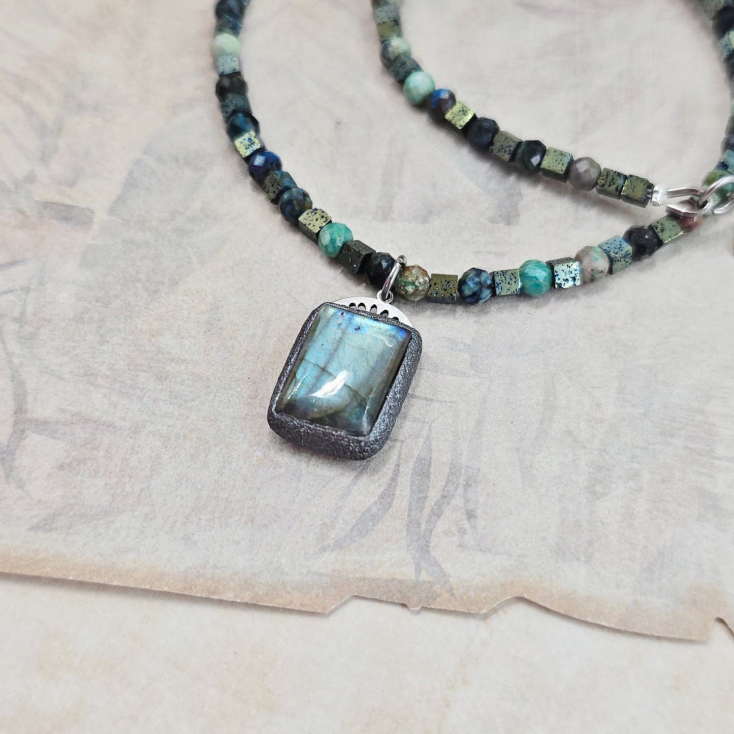 Trumpas vėrinys su labradoritu, turkiu ir hematitu