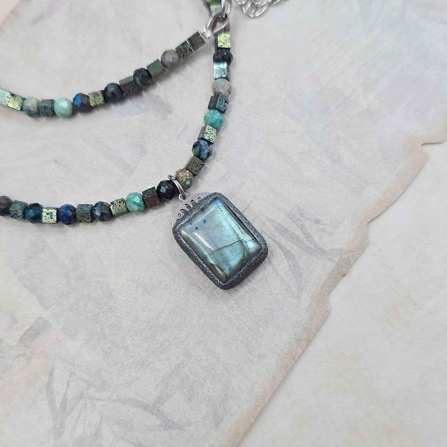 Trumpas vėrinys su labradoritu, turkiu ir hematitu