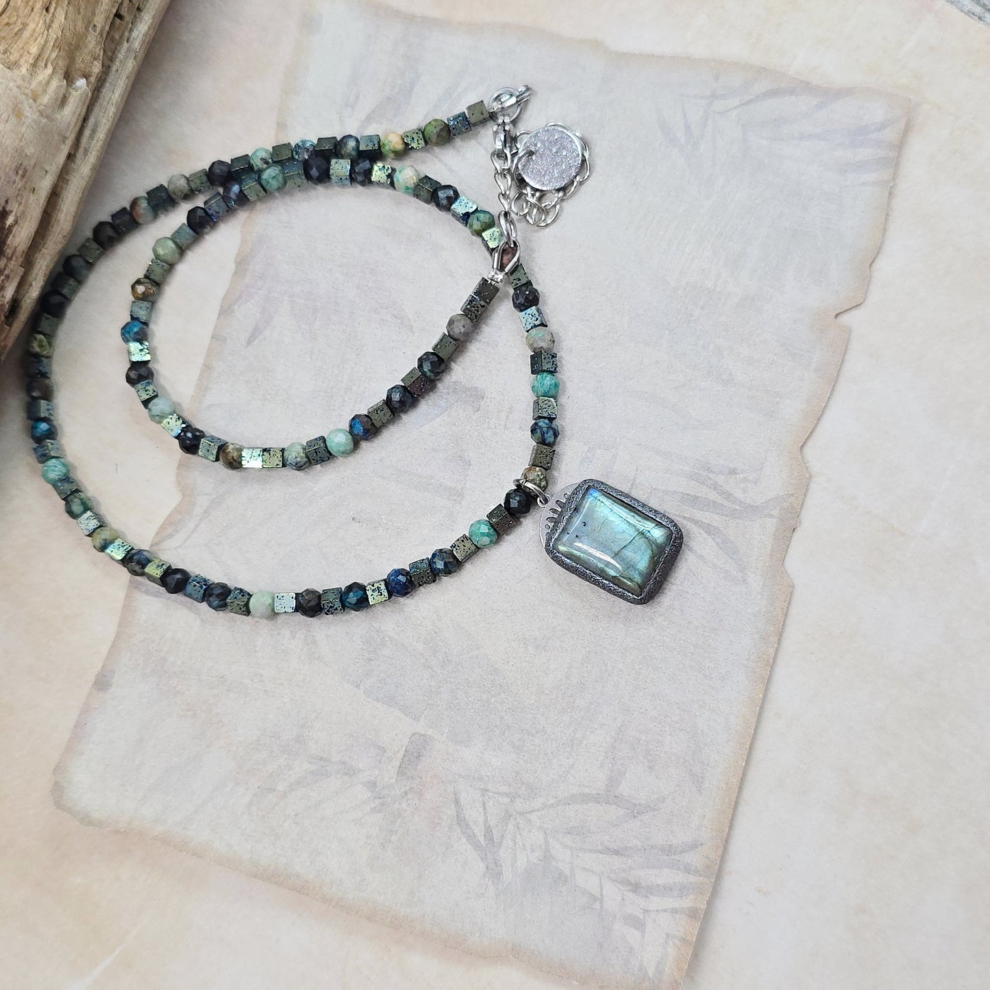 Trumpas vėrinys su labradoritu, turkiu ir hematitu