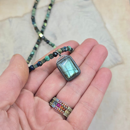 Trumpas vėrinys su labradoritu, turkiu ir hematitu