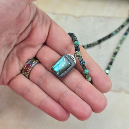 Trumpas vėrinys su labradoritu, turkiu ir hematitu