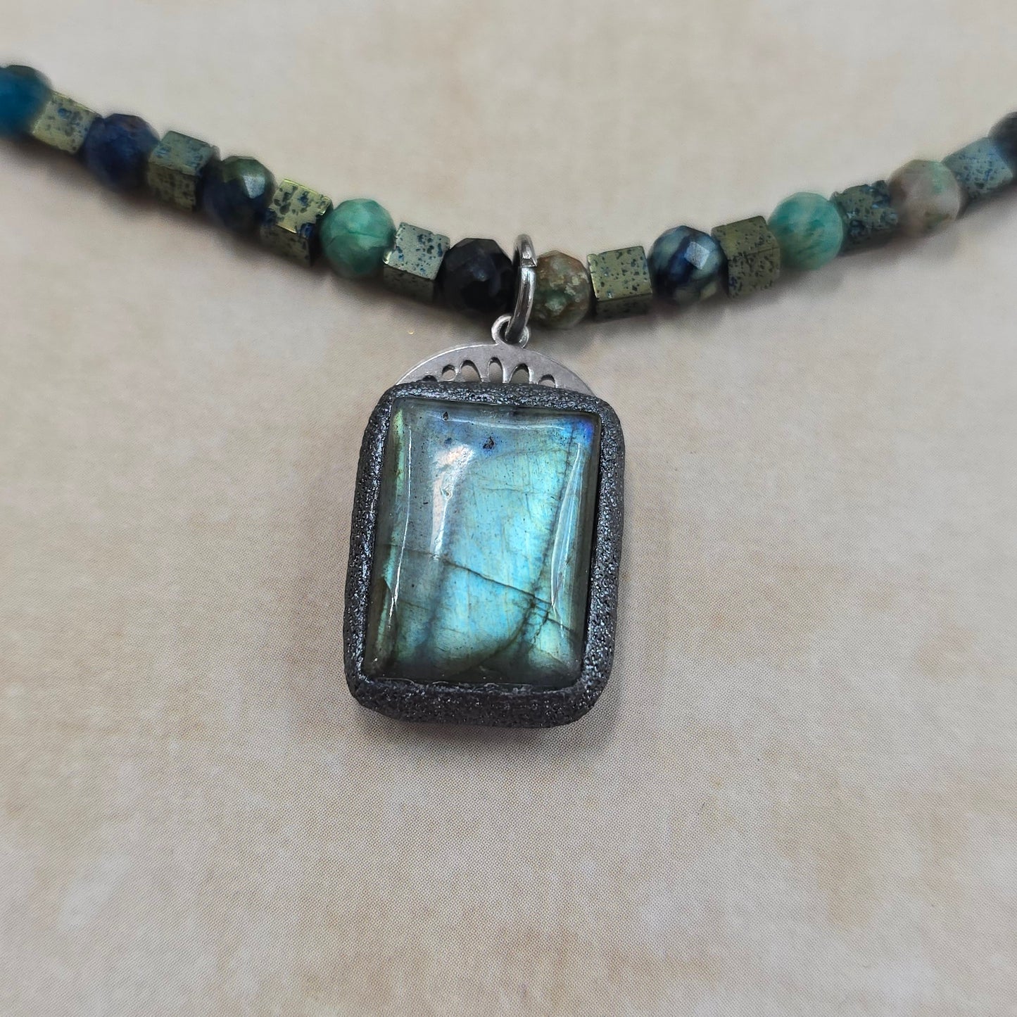 Trumpas vėrinys su labradoritu, turkiu ir hematitu