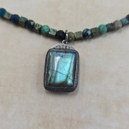 Trumpas vėrinys su labradoritu, turkiu ir hematitu