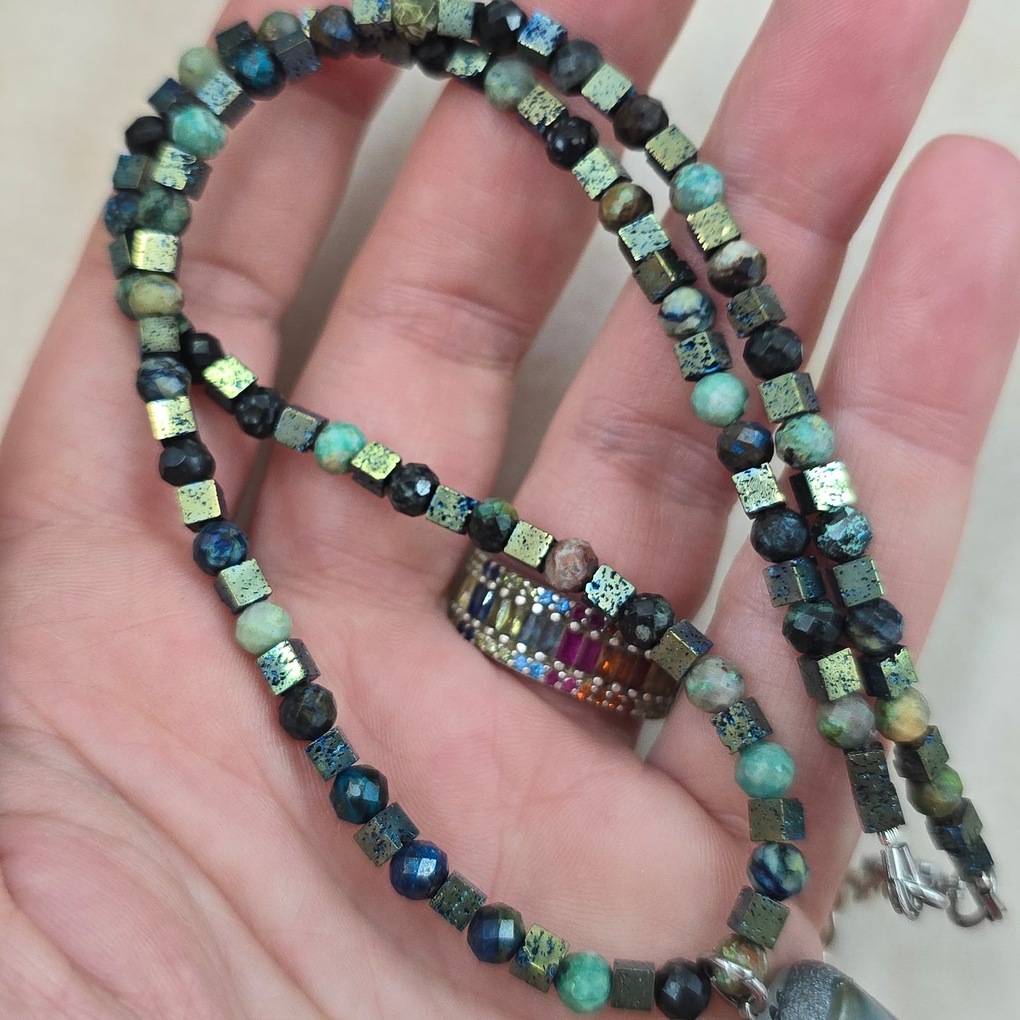 Trumpas vėrinys su labradoritu, turkiu ir hematitu