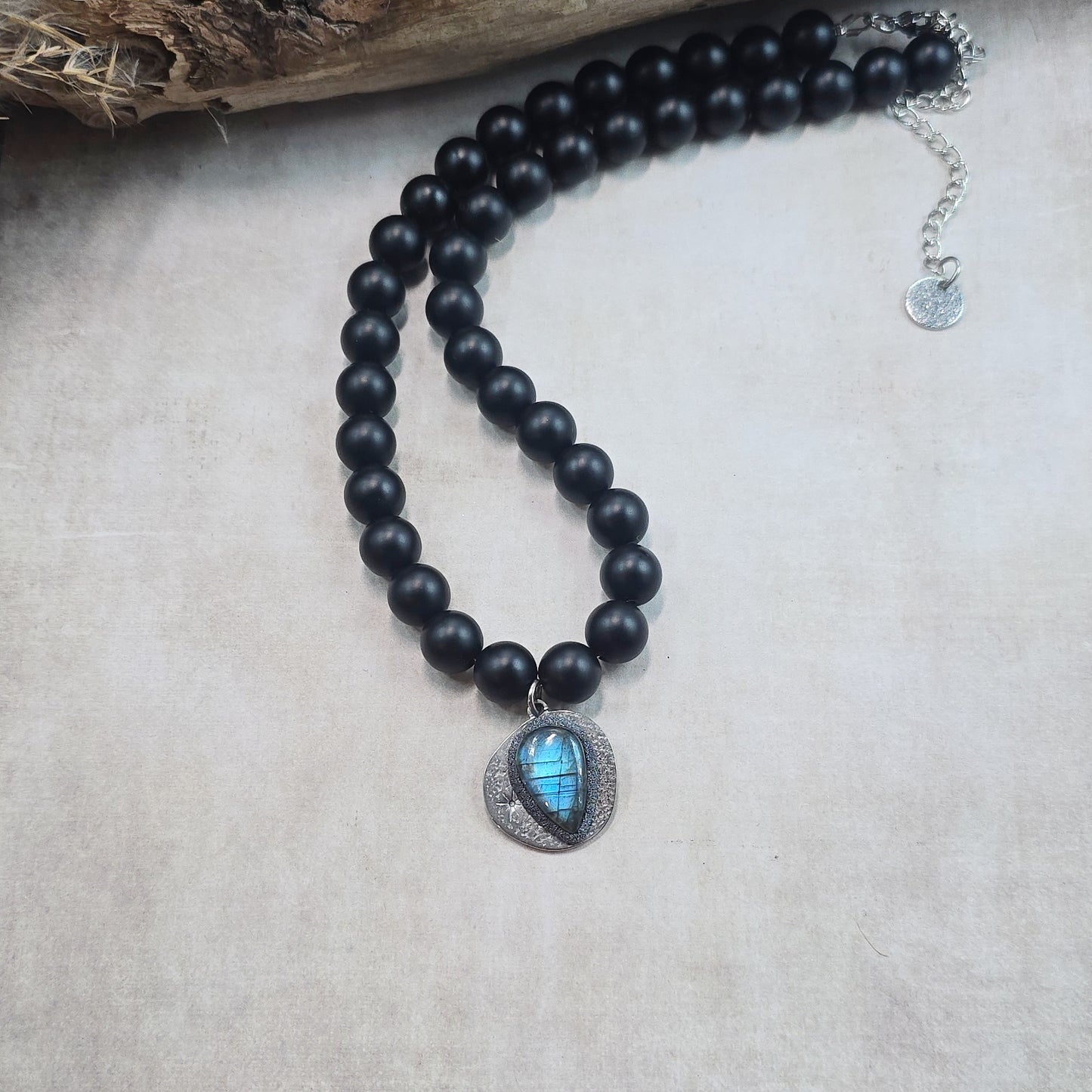 Trumpas vėrinys su labradoritu ir šungitu