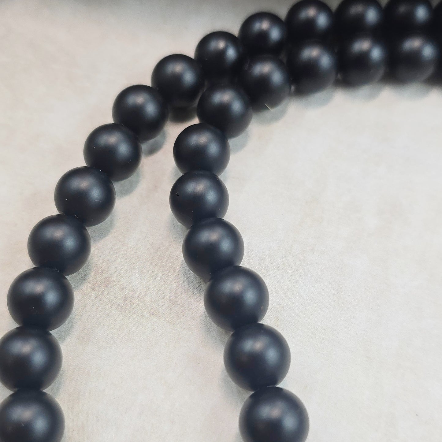 Trumpas vėrinys su labradoritu ir šungitu