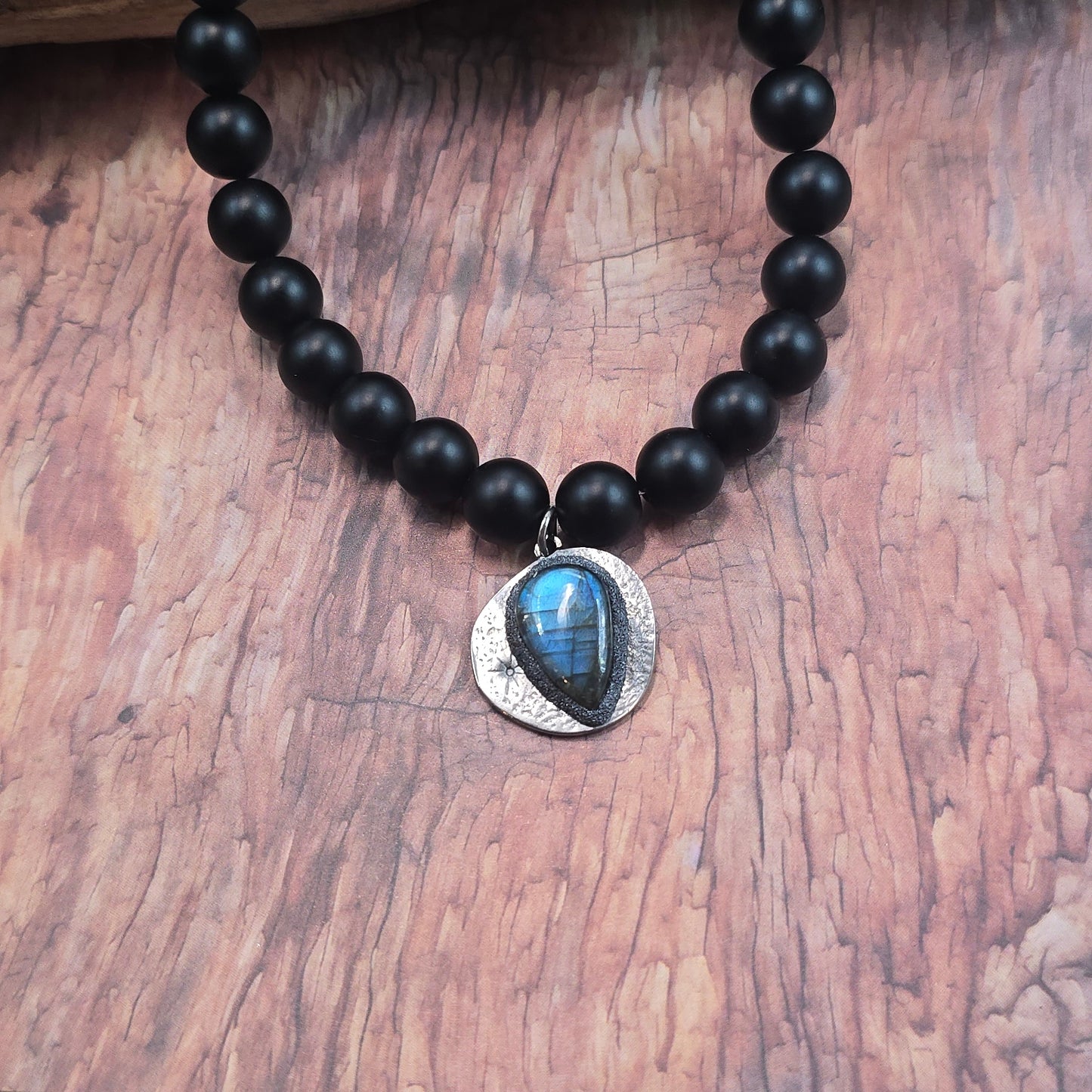 Trumpas vėrinys su labradoritu ir šungitu