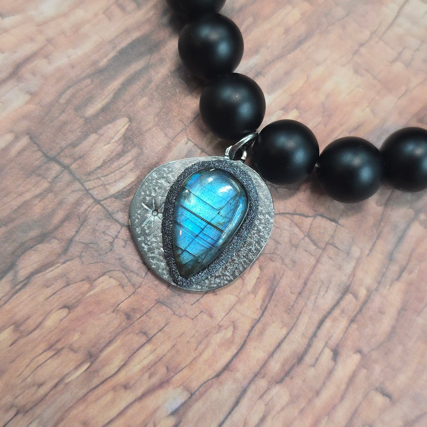 Trumpas vėrinys su labradoritu ir šungitu