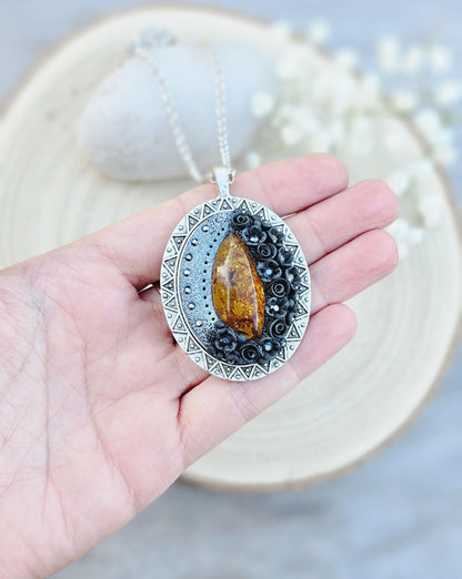 Pendant locket with amber, handmade flowers from polymer clay. On the other side, there is a locket with a heart that opens, inside which you can put a photo or a scent. A great gift for a loved one, or for yourself as a protective amulet.